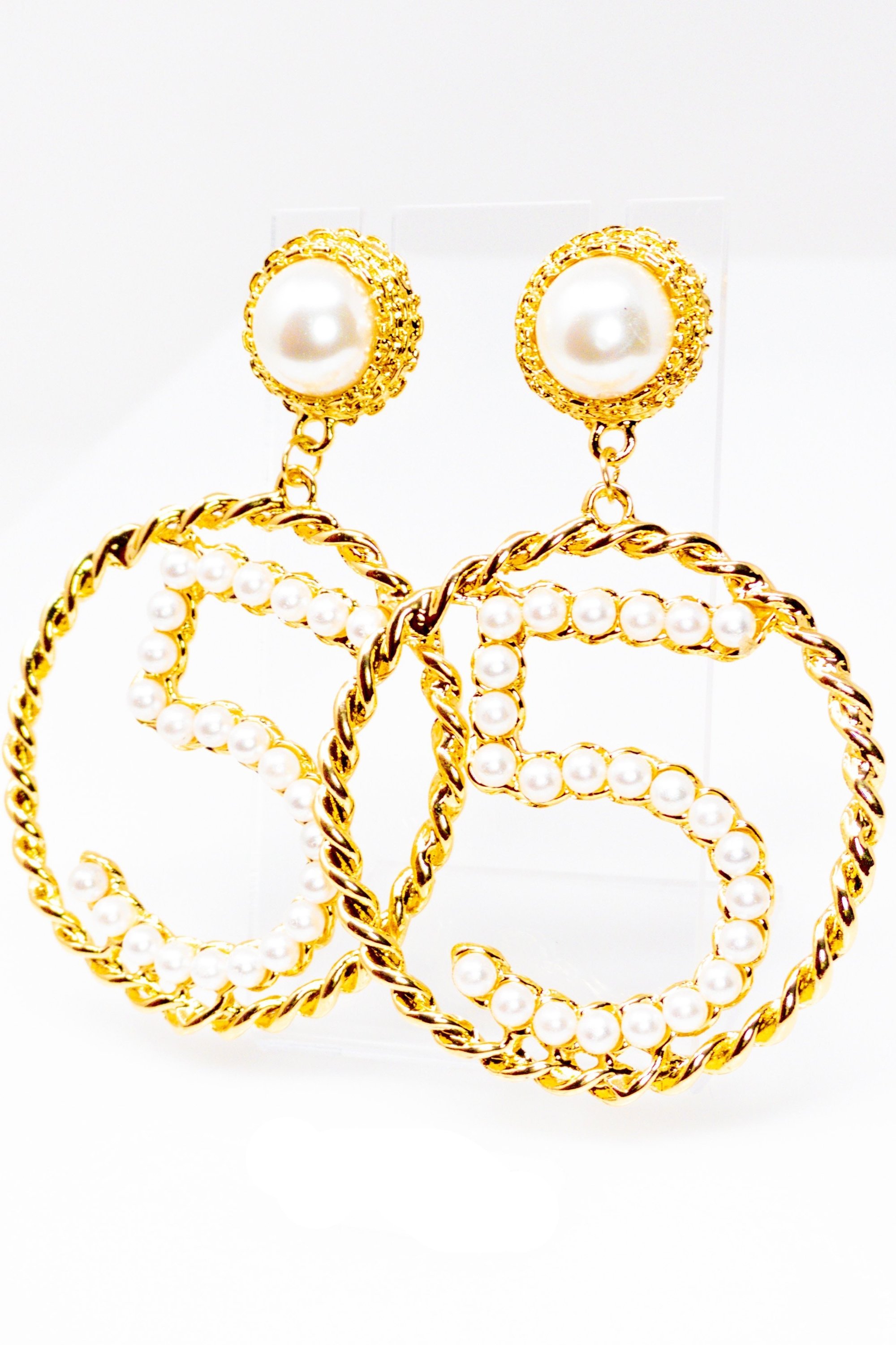 Elegant gold drop hoop earrings made from satin ribbon and brass, featuring a unique geometric design.