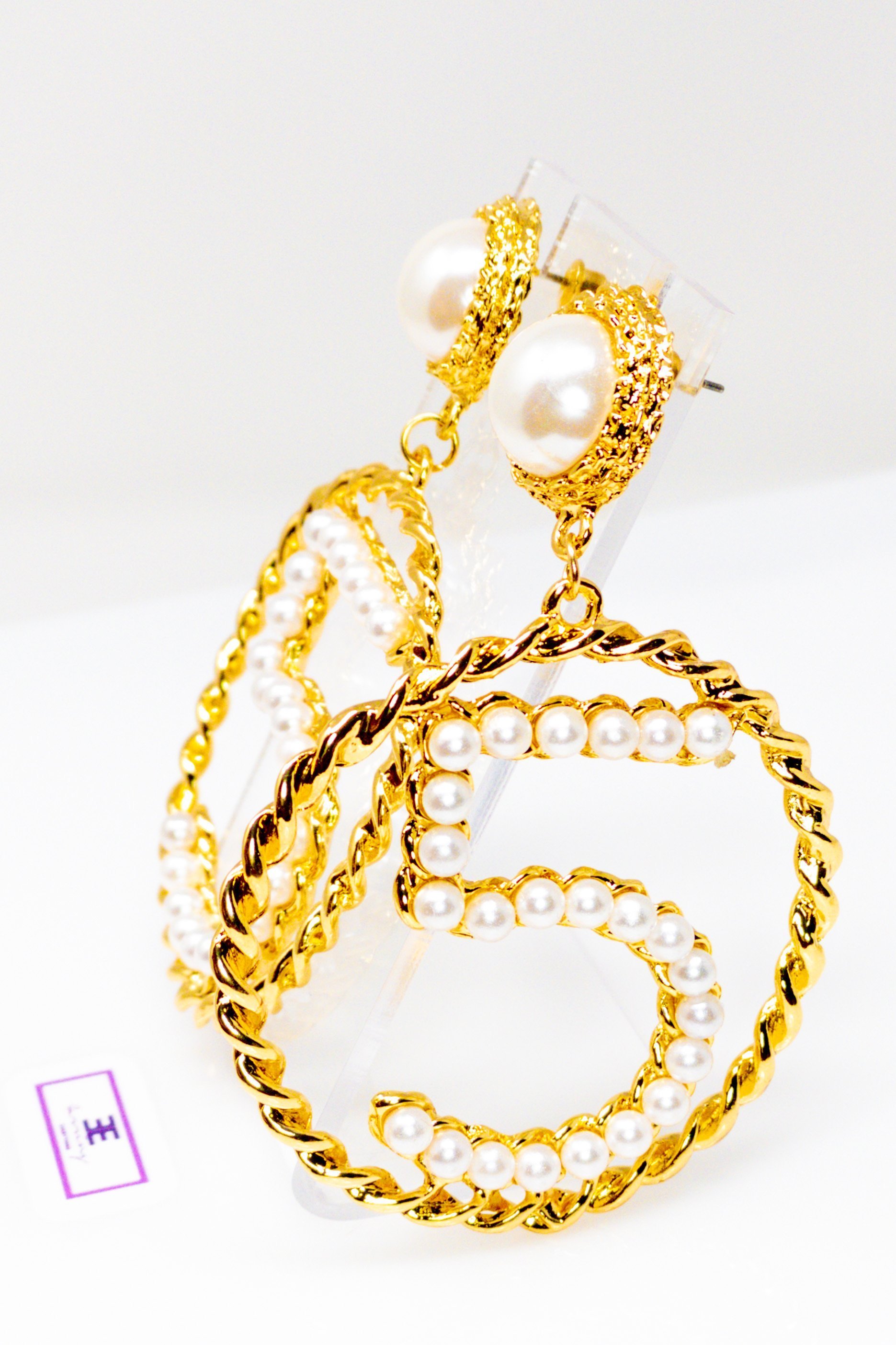 Elegant gold drop hoop earrings made from satin ribbon and brass, featuring a unique geometric design.