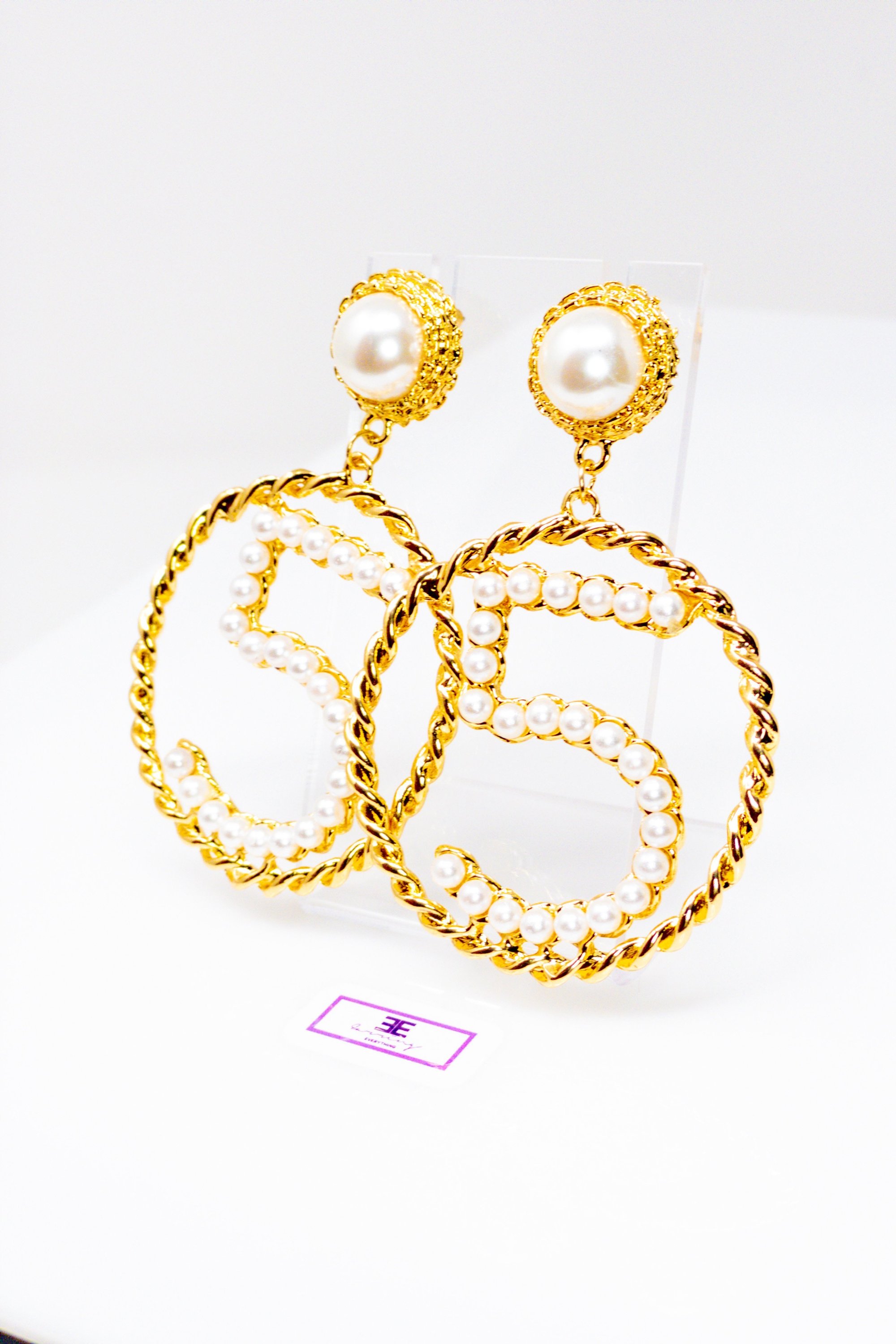 Elegant gold drop hoop earrings made from satin ribbon and brass, featuring a unique geometric design.