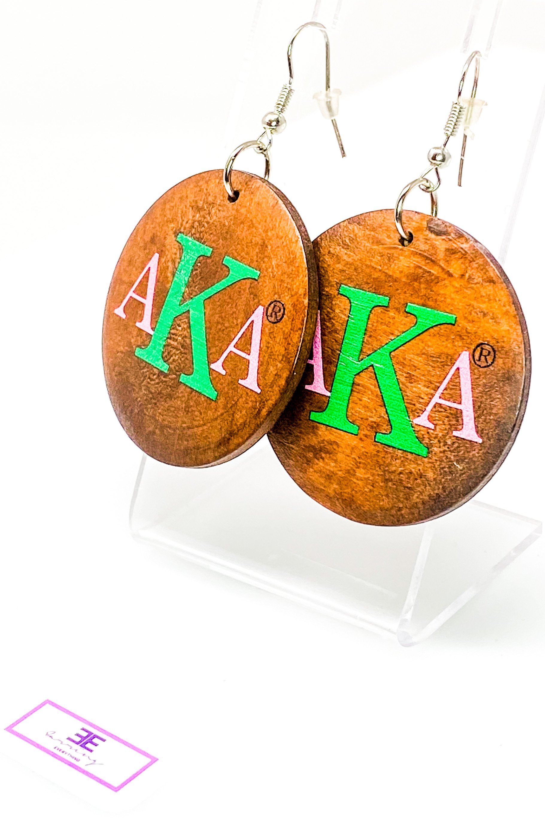 A pair of stylish black wooden monogrammed drop earrings featuring a round shape and front and back print design.