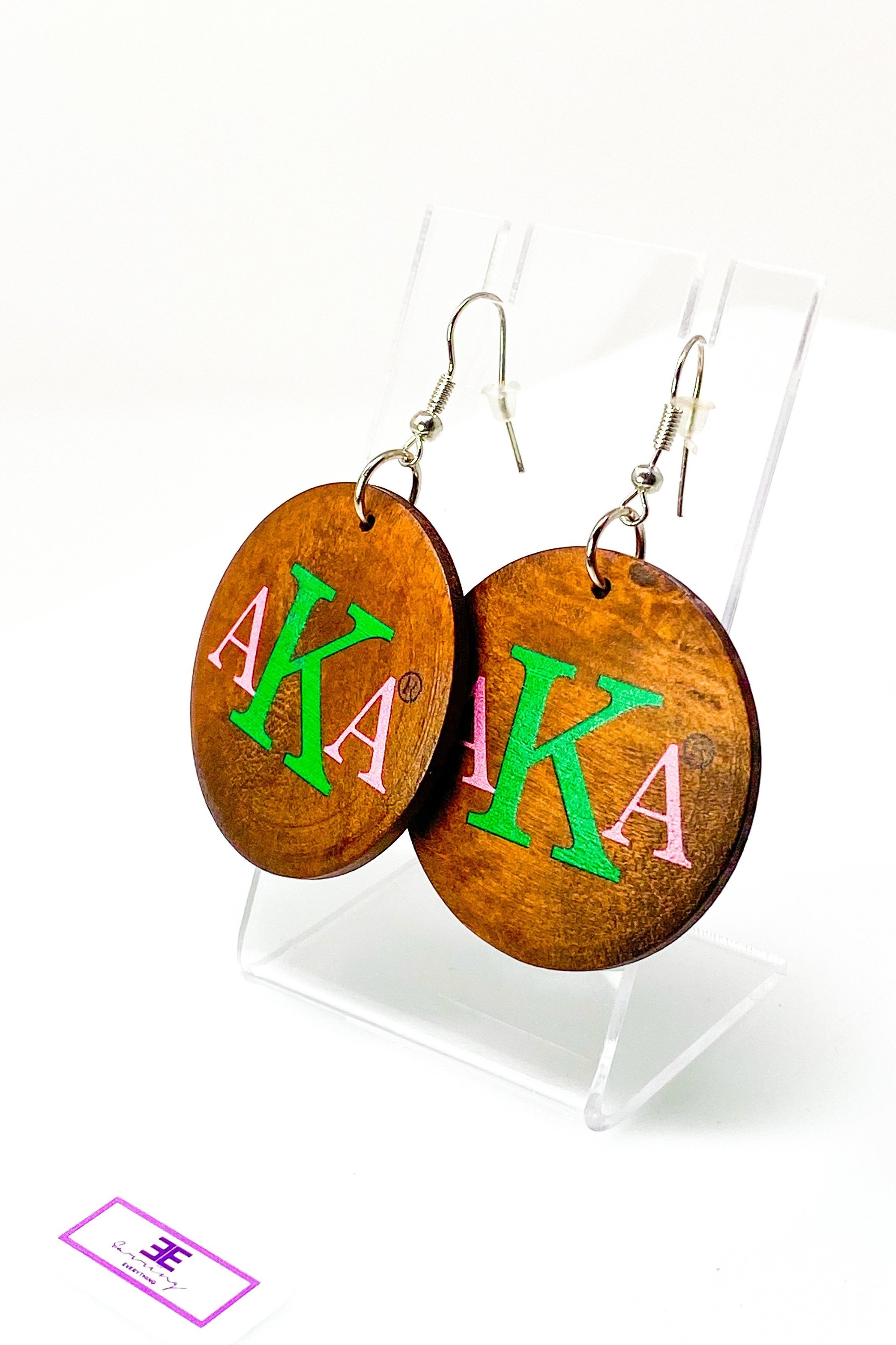 A pair of stylish black wooden monogrammed drop earrings featuring a round shape and front and back print design.