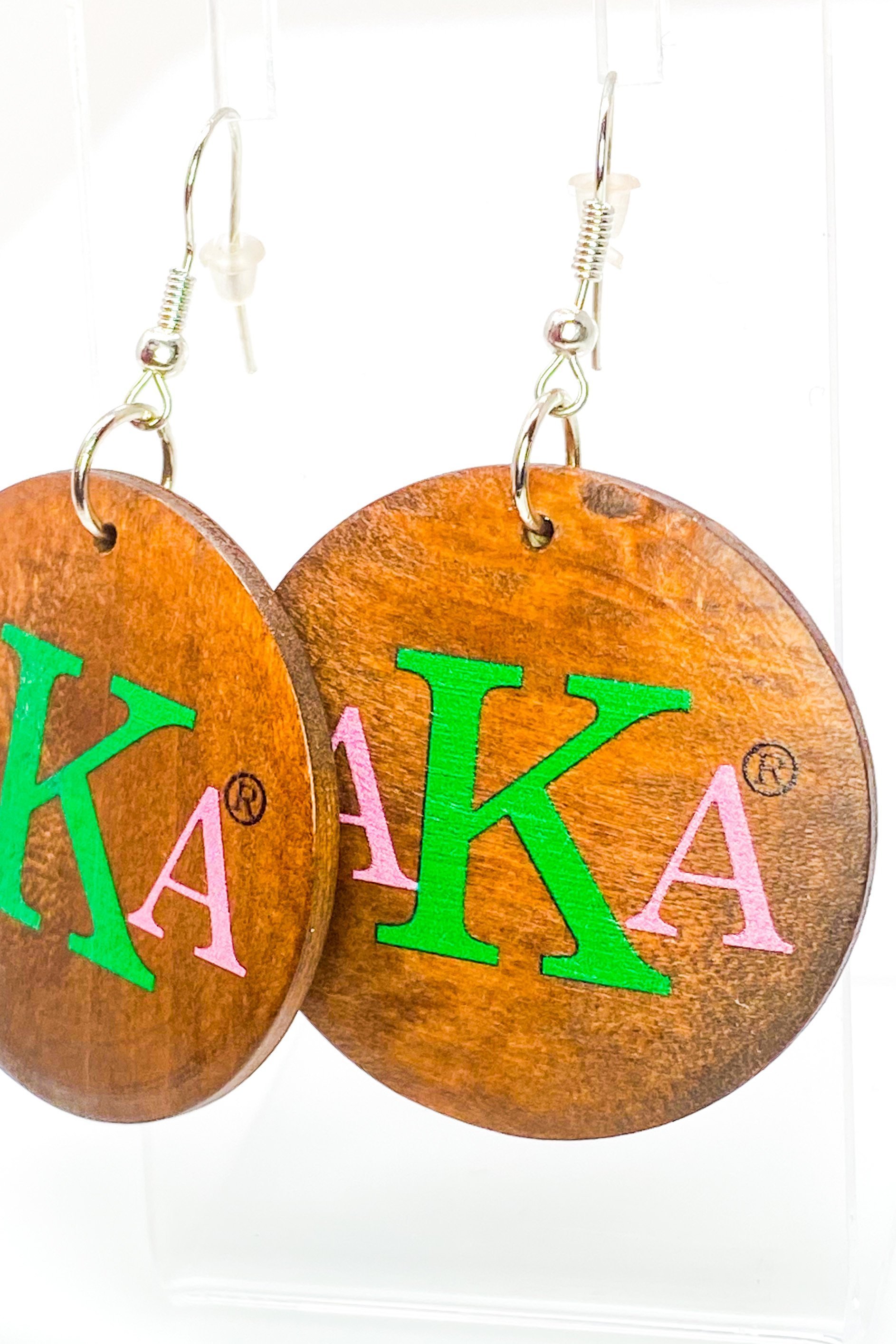 A pair of stylish black wooden monogrammed drop earrings featuring a round shape and front and back print design.