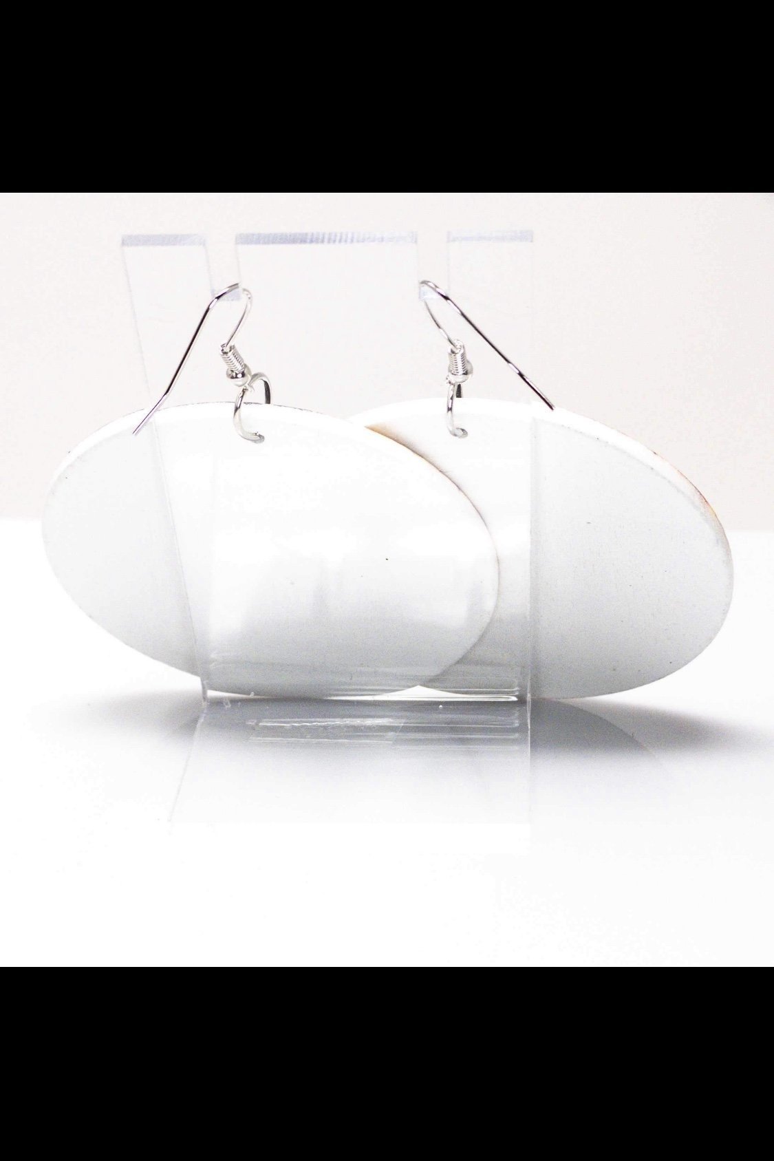 White oval earrings on display.