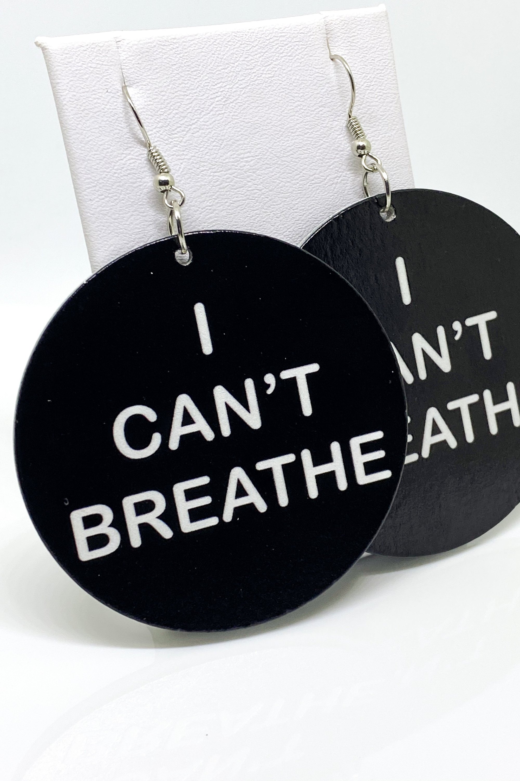 Hoops - I Can’t Breathe earrings featuring a round wooden design with a black print, showcasing their cultural and stylish appeal.