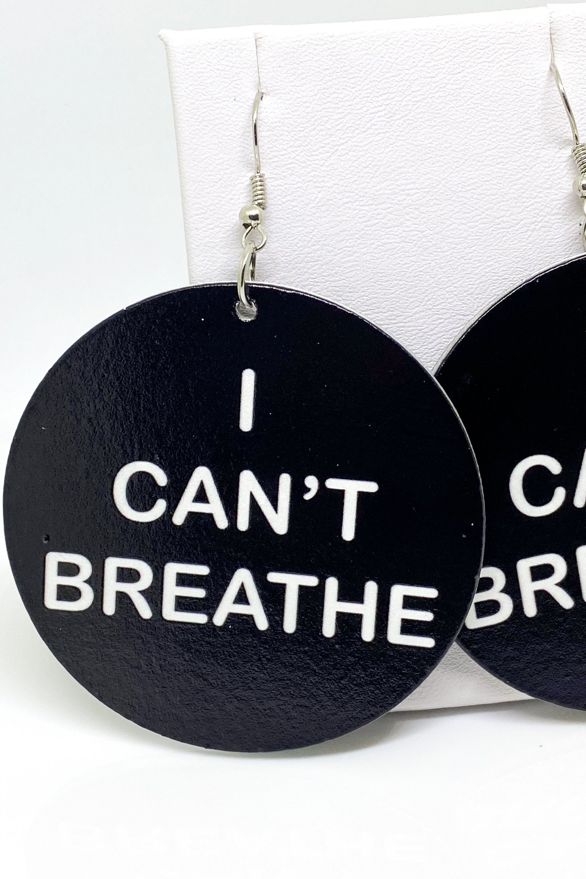 Hoops - I Can’t Breathe earrings featuring a round wooden design with a black print, showcasing their cultural and stylish appeal.