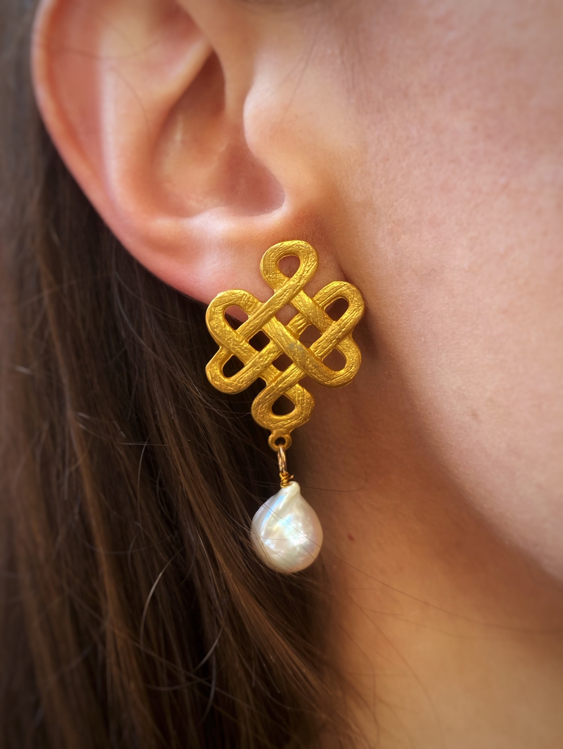 Elegant Intreccio Earrings featuring a gold braided design and dangling baroque pearl, handcrafted in Sicily.