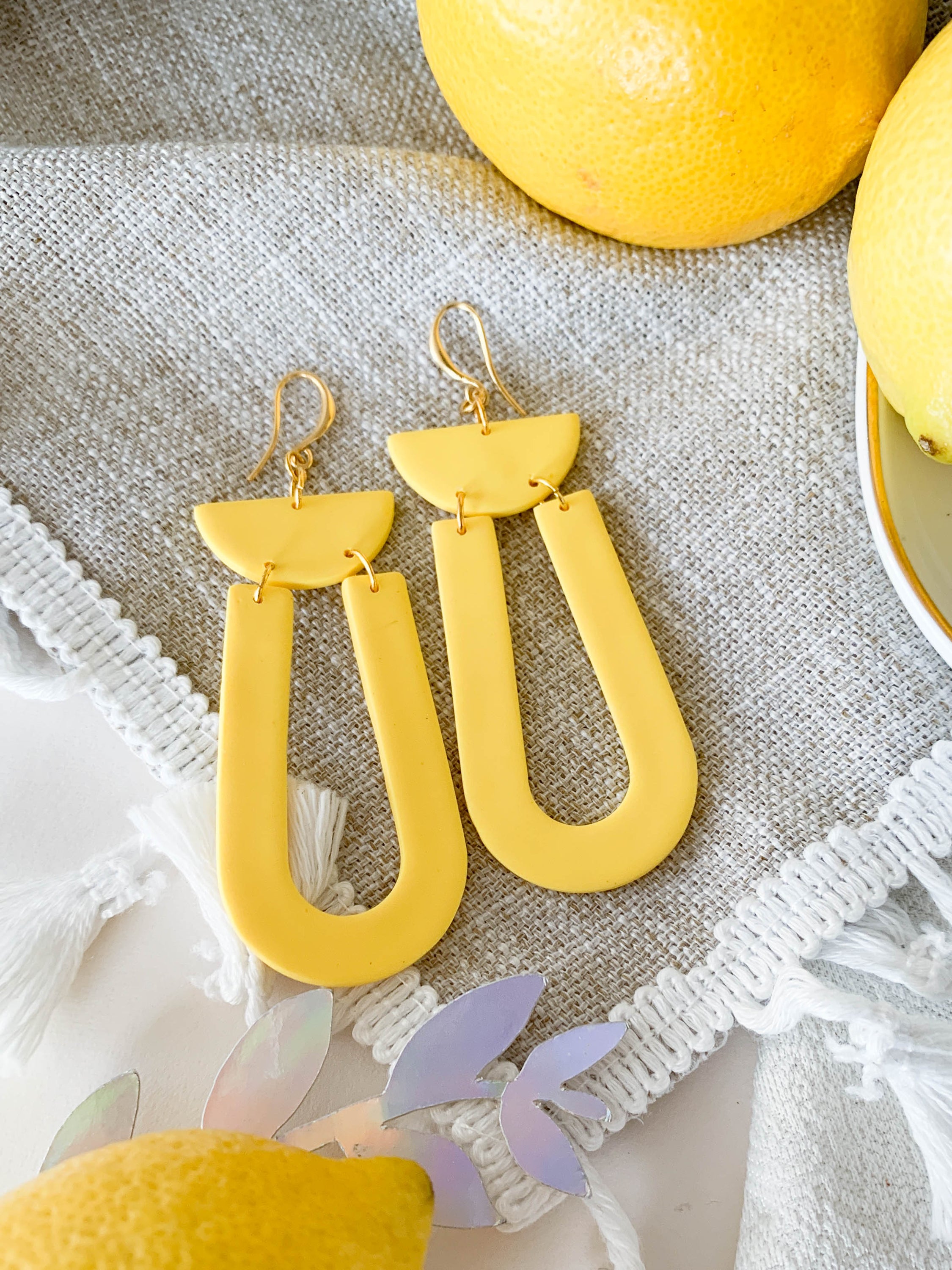 Josie Lemon geometric loop dangle earrings in bright yellow with gold plated hooks, showcasing a cheerful and modern design.