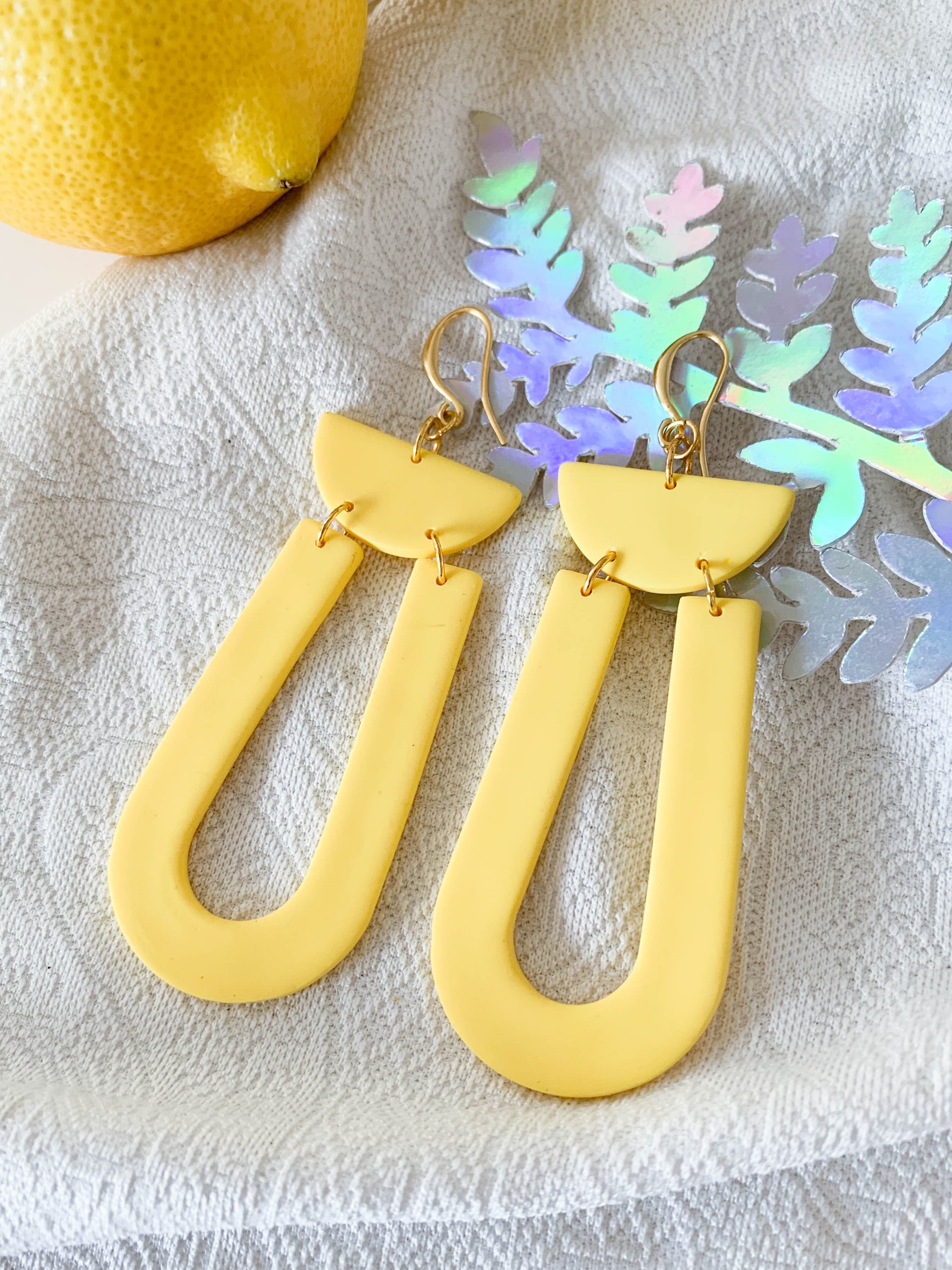 Josie Lemon geometric loop dangle earrings in bright yellow with gold plated hooks, showcasing a cheerful and modern design.