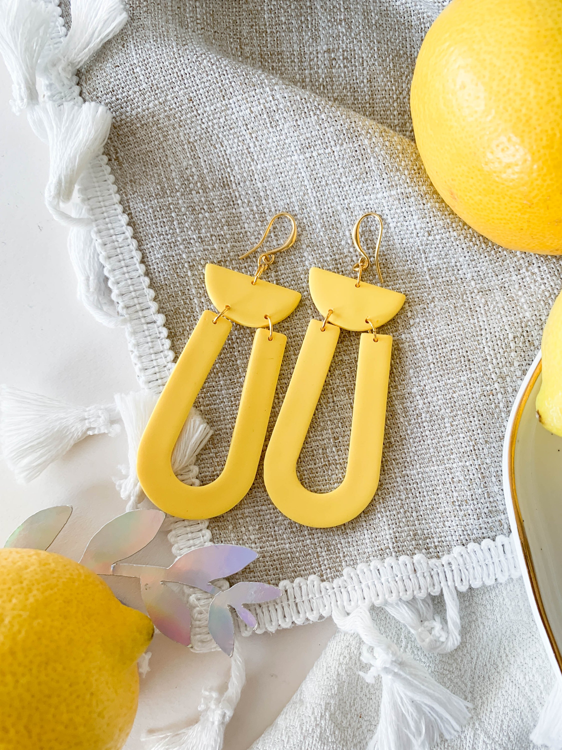 Josie Lemon geometric loop dangle earrings in bright yellow with gold plated hooks, showcasing a cheerful and modern design.