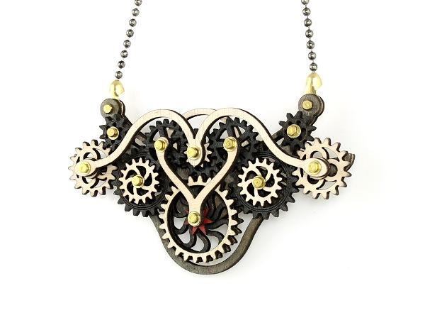 Kinetic Winged Gear Necklace 6004C featuring moving gears, made from sustainably sourced wood in gray, black, and cherry red colors.