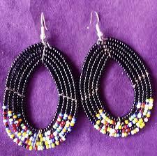 A pair of Maasai beaded earrings featuring vibrant wine red African seed beads in an elegant oval shape.