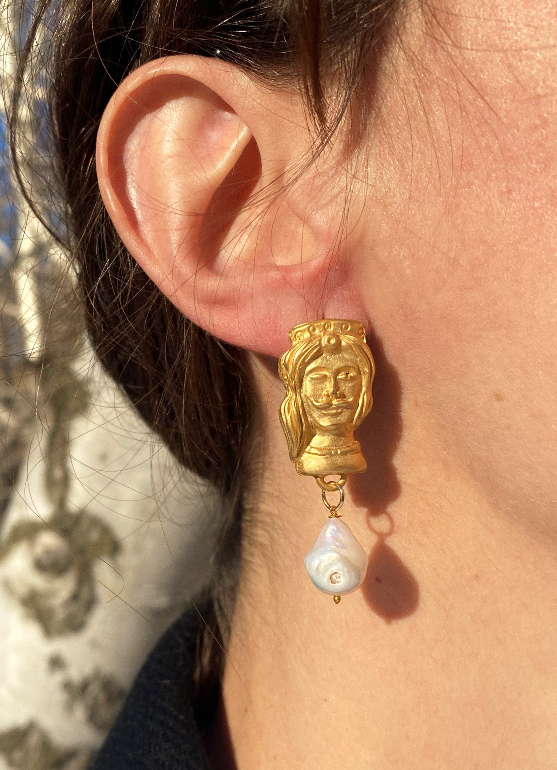 Handcrafted Moor's Head Earrings made of brass and natural pearls, showcasing intricate design inspired by Sicilian culture.