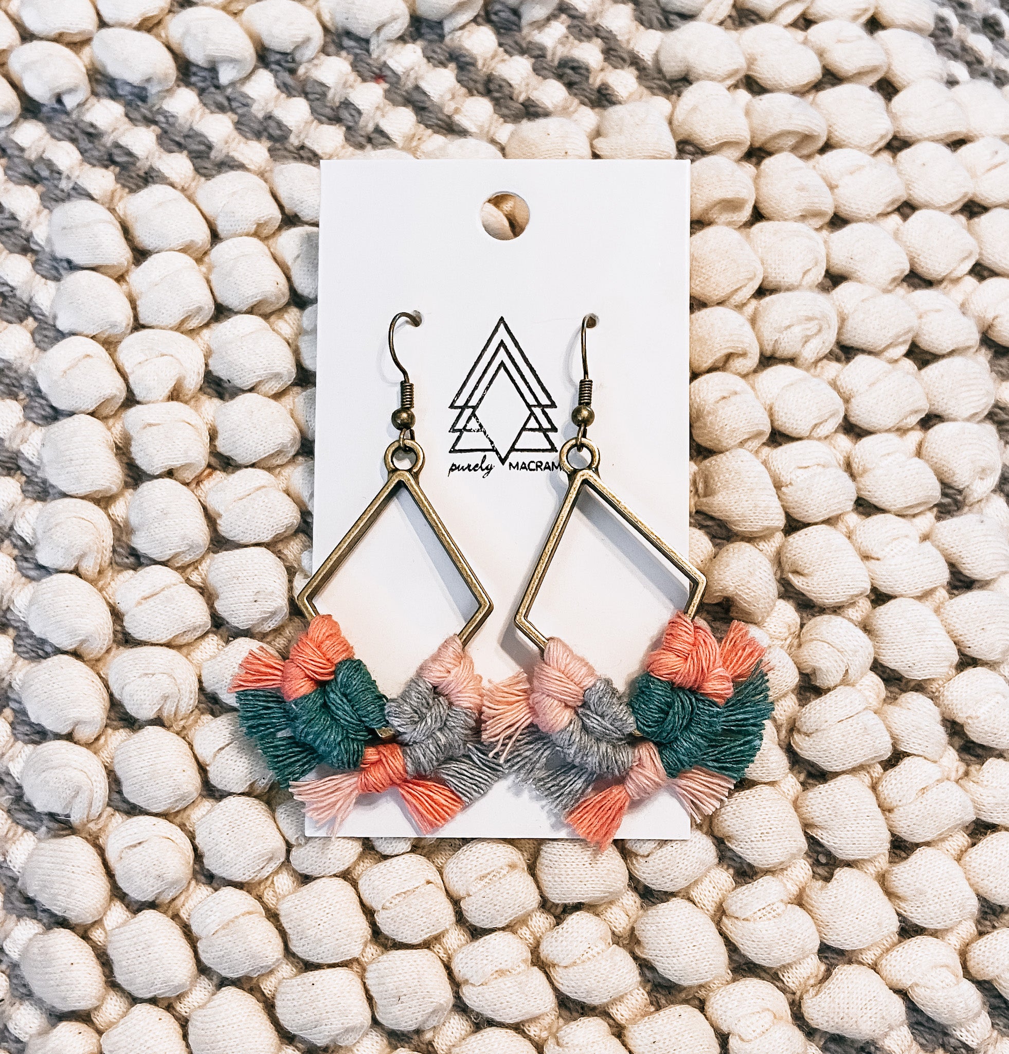 A collection of multi-colored diamond-shaped macrame cotton accessories, showcasing vibrant patterns and lightweight design.