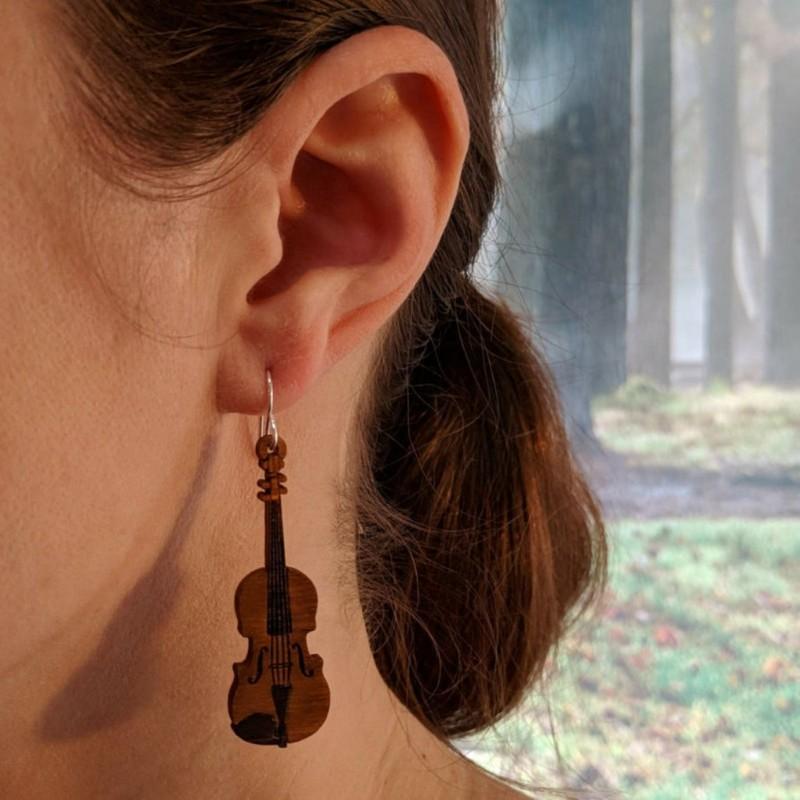 A pair of lightweight wooden earrings shaped like various musical instruments, including guitars and drums, with sterling silver ear wires.