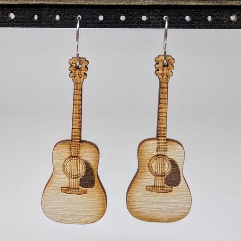 A pair of lightweight wooden earrings shaped like various musical instruments, including guitars and drums, with sterling silver ear wires.