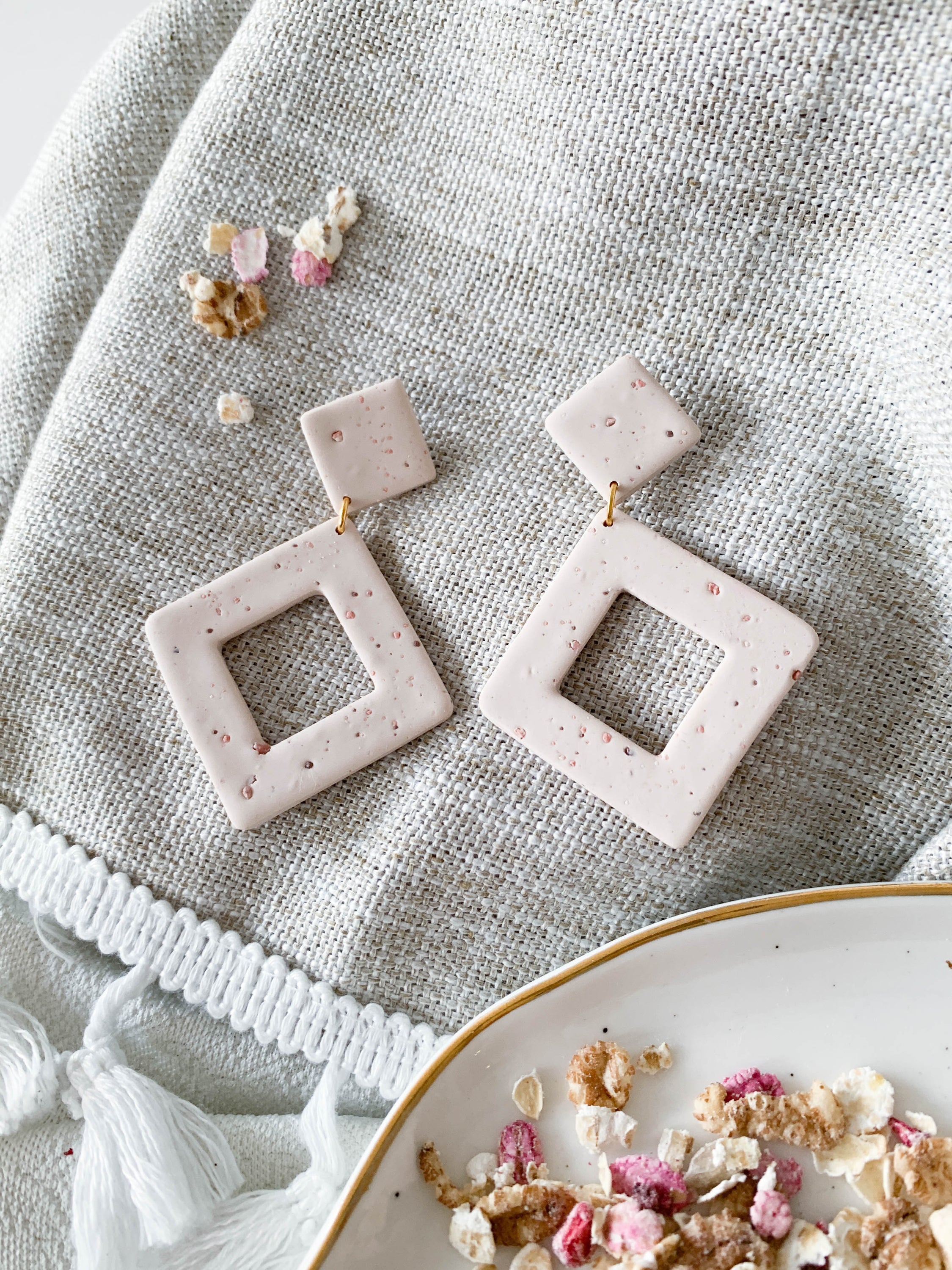 Nicole Oat Milk earrings featuring a minimalist rhombus design in soft colors, handmade from polymer clay with unique speckle patterns.