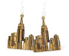 A pair of tan NY Cityscape Earrings featuring a laser-cut design inspired by New York City's skyline, made from sustainable wood.