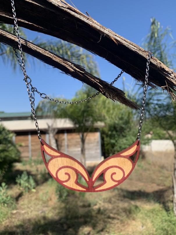 Ornamental Scroll Necklace #6135 featuring a vibrant wine color, laser-cut wood design, and adjustable stainless steel chain.