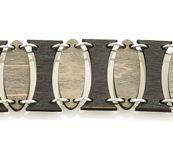 Oval Pillar Bracelet 7501E in black satin and gray, showcasing its elegant design and natural wood back for essential oil diffusion.