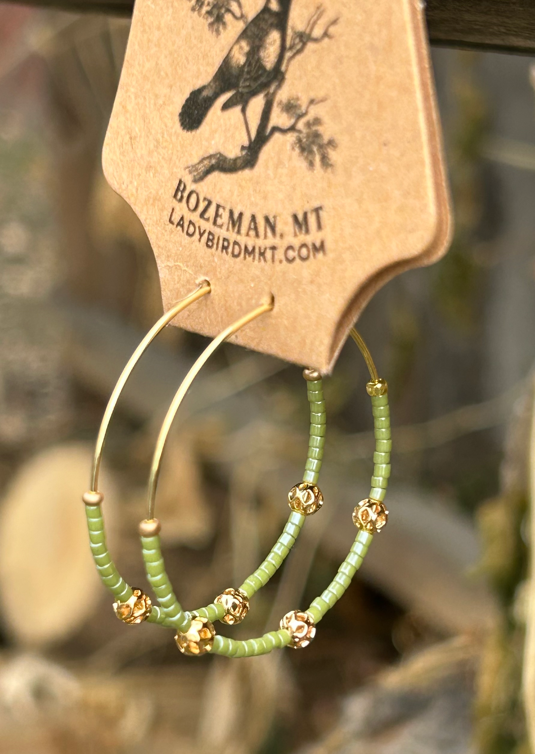 Pale green and gold beaded hoop earrings featuring Miyuki Delica seed beads and metallic gold lattice beads, elegantly designed for bohemian style.