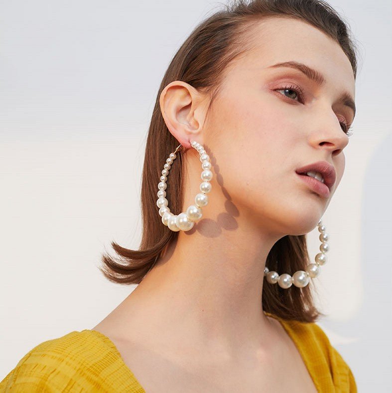 Trendy Pearl Girl Glam hoop earrings featuring pearl-like beads and gold accents, perfect for stylish accessorizing.