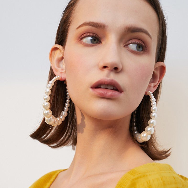 Trendy Pearl Girl Glam hoop earrings featuring pearl-like beads and gold accents, perfect for stylish accessorizing.