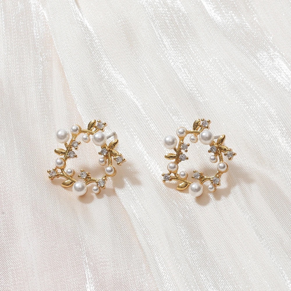 Elegant gold-plated pearl wreath earrings adorned with small diamonds, showcasing a luxurious and sophisticated design.