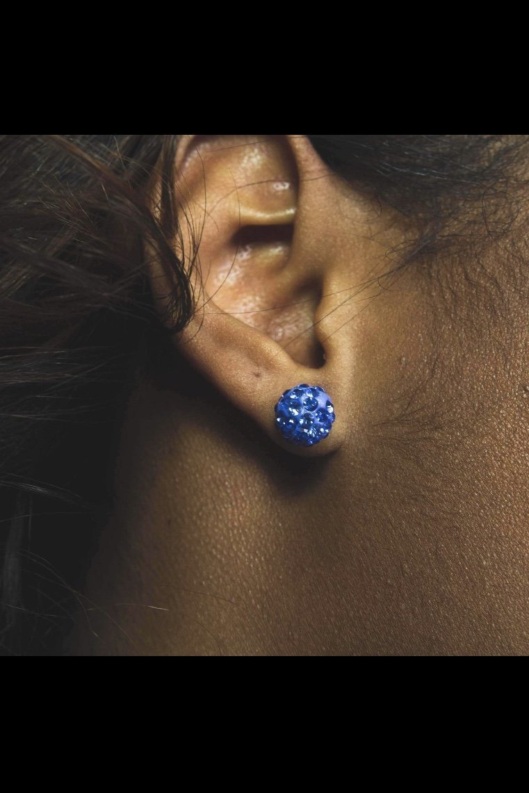 A pair of round ceramic stud earrings with a sparkling finish, featuring a nickel-free brass back finding, perfect for casual wear.