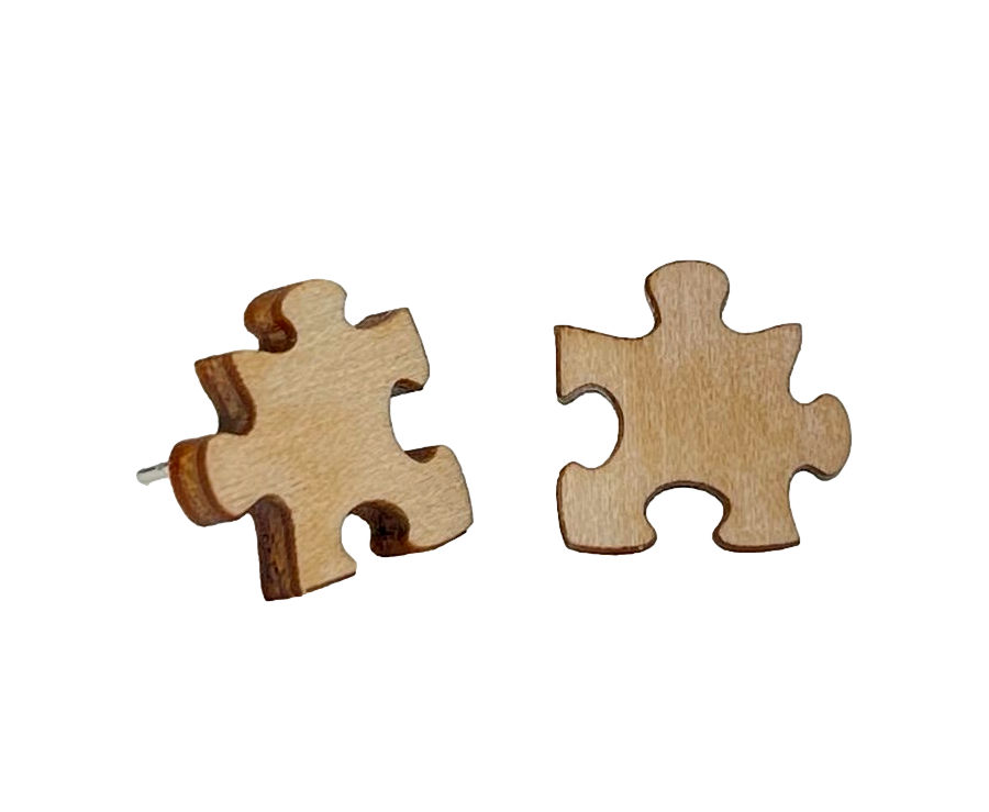 A pair of Puzzle Piece Stud Earrings made from sustainably sourced wood with silver-finished stainless steel ear wires, featuring a unique laser-cut design.