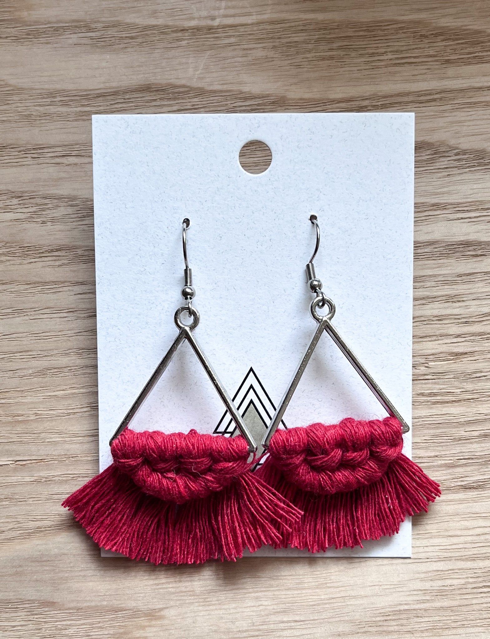 A pair of lightweight red triangle earrings made from 100% macrame cotton, showcasing a modern and stylish design.