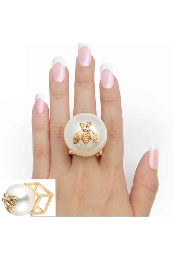 Elegant ring featuring a metal bee casting and a large pearl, set on a 3D metal cube, showcasing intricate design and craftsmanship.