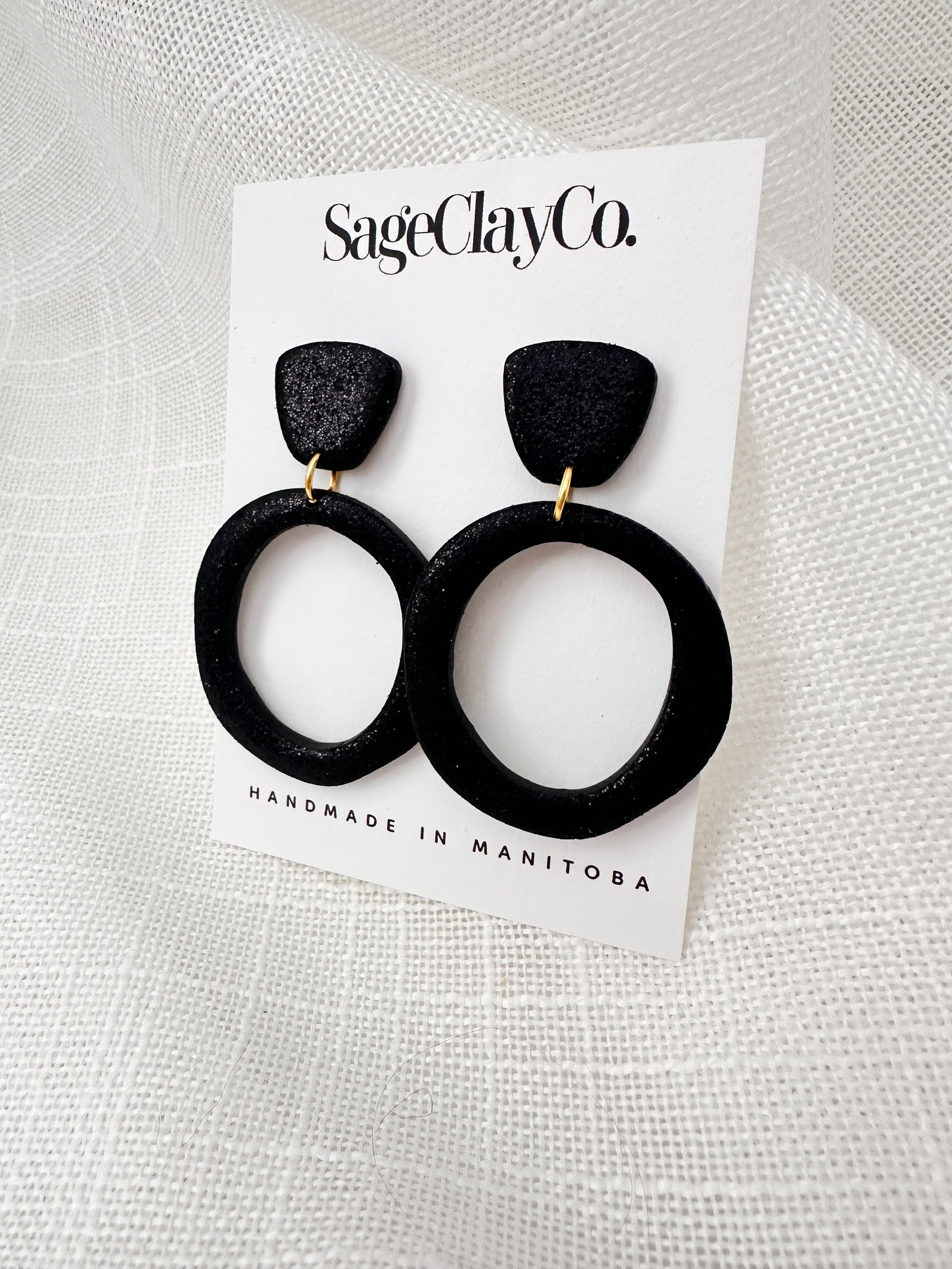 Handmade sparkly black hoop studs with hypoallergenic posts, showcasing unique craftsmanship and lightweight design.