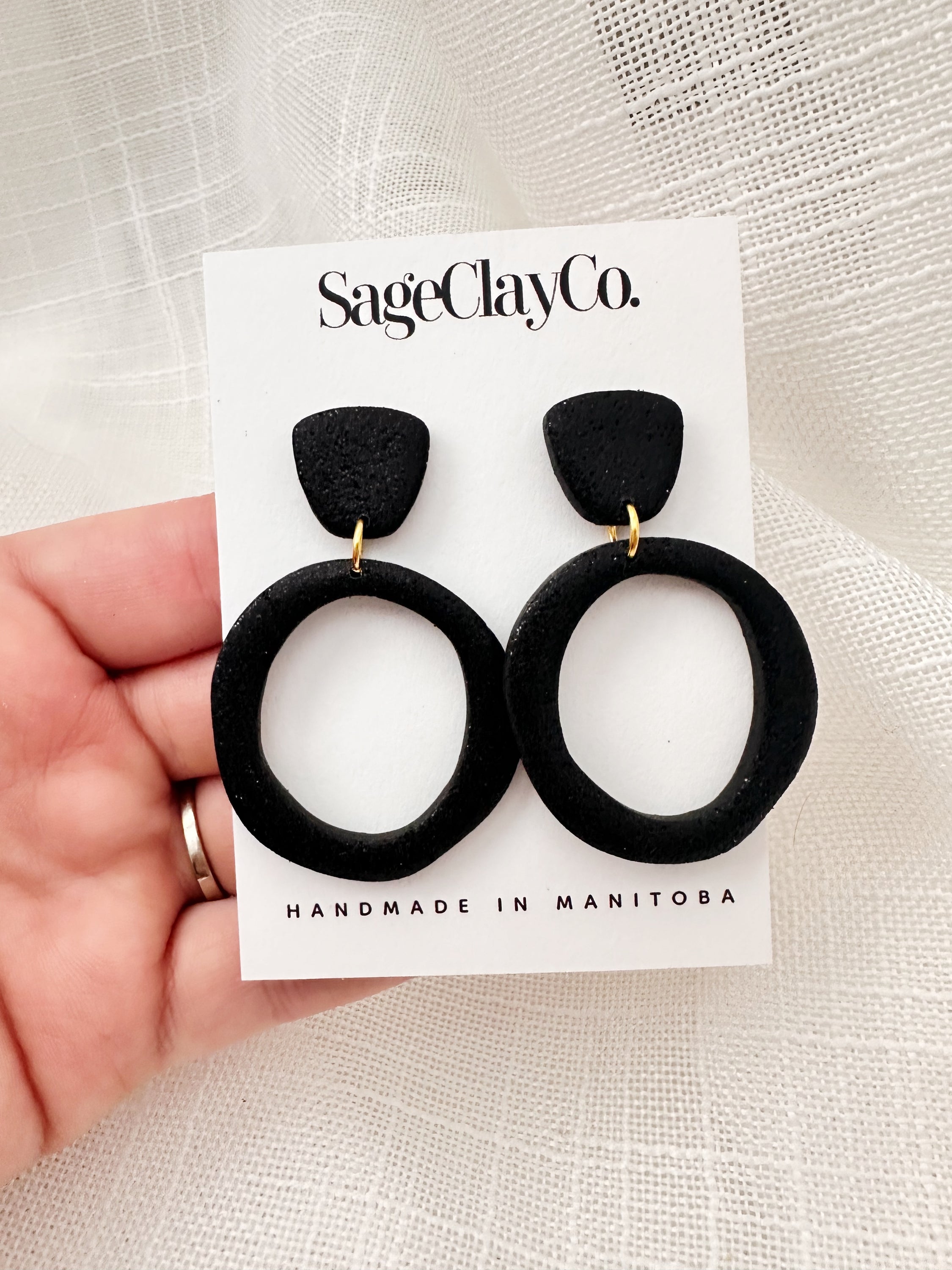 Handmade sparkly black hoop studs with hypoallergenic posts, showcasing unique craftsmanship and lightweight design.