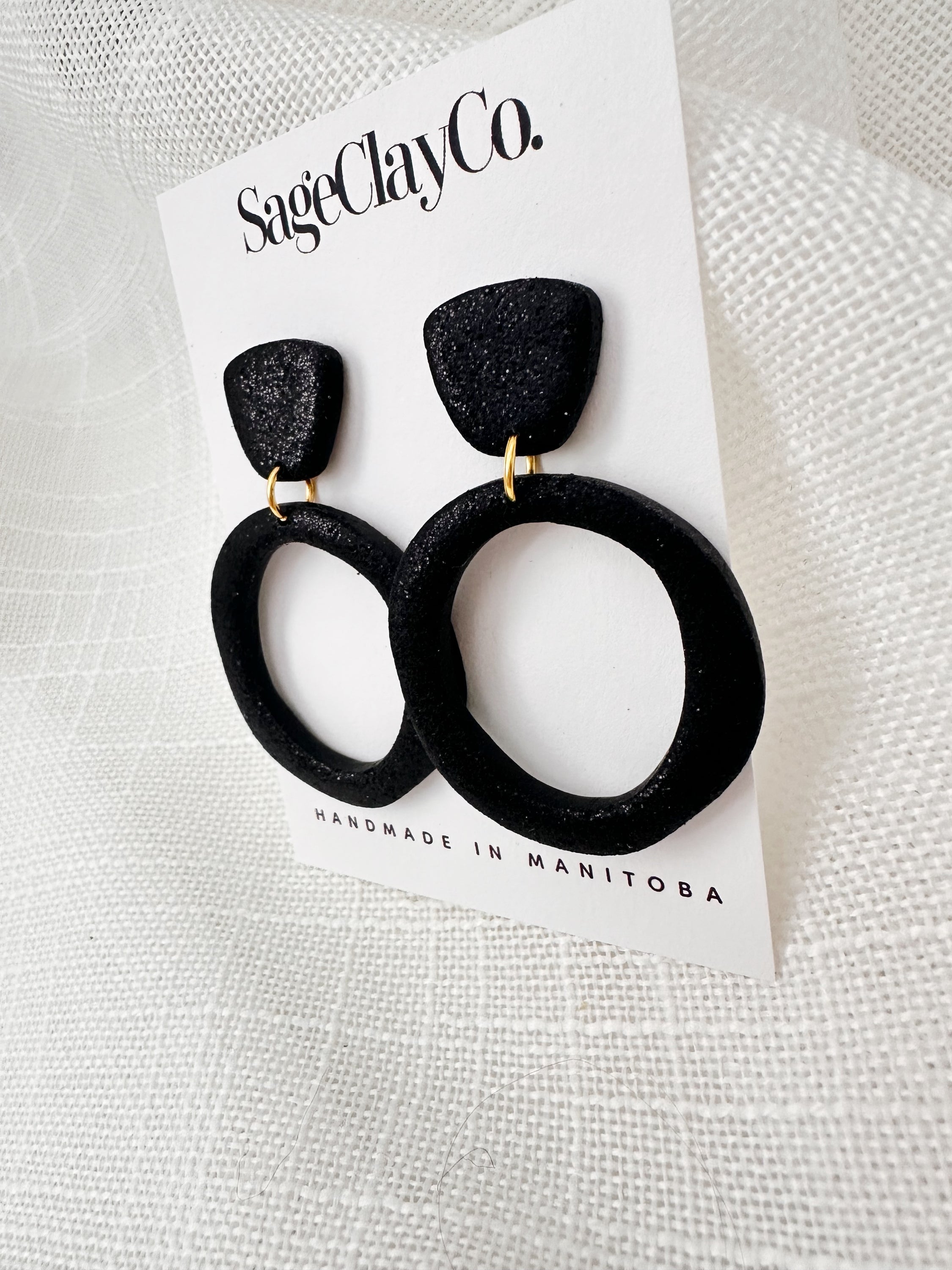 Handmade sparkly black hoop studs with hypoallergenic posts, showcasing unique craftsmanship and lightweight design.