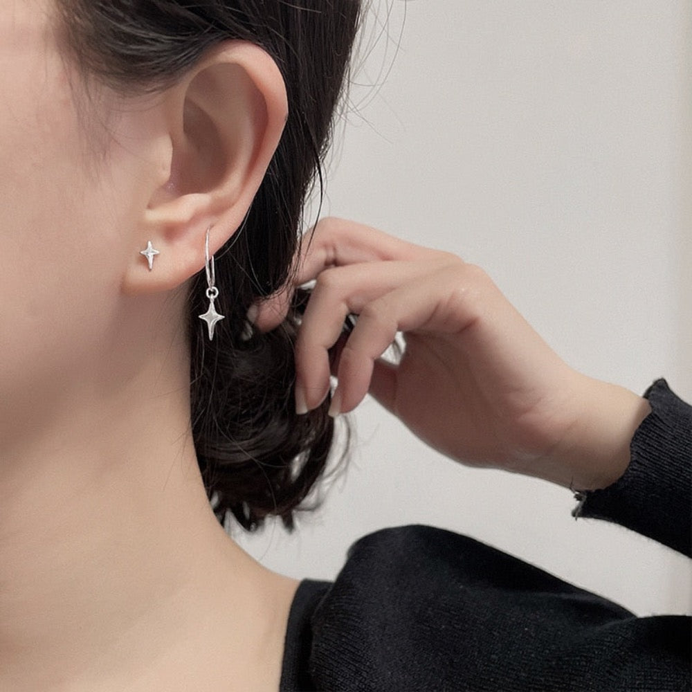 A pair of asymmetrical star earrings featuring one hoop star earring and one star stud, crafted from silver-colored copper and metal.