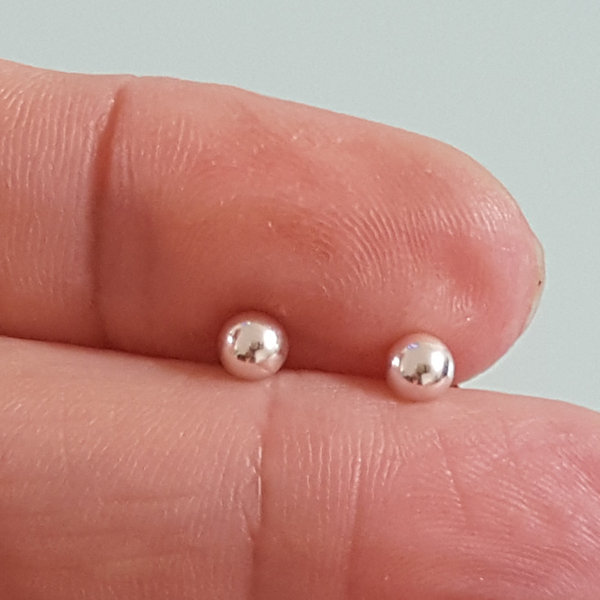 A pair of elegant 3 mm ball stud earrings made from sterling silver, featuring a secure disc butterfly back for comfortable wear.