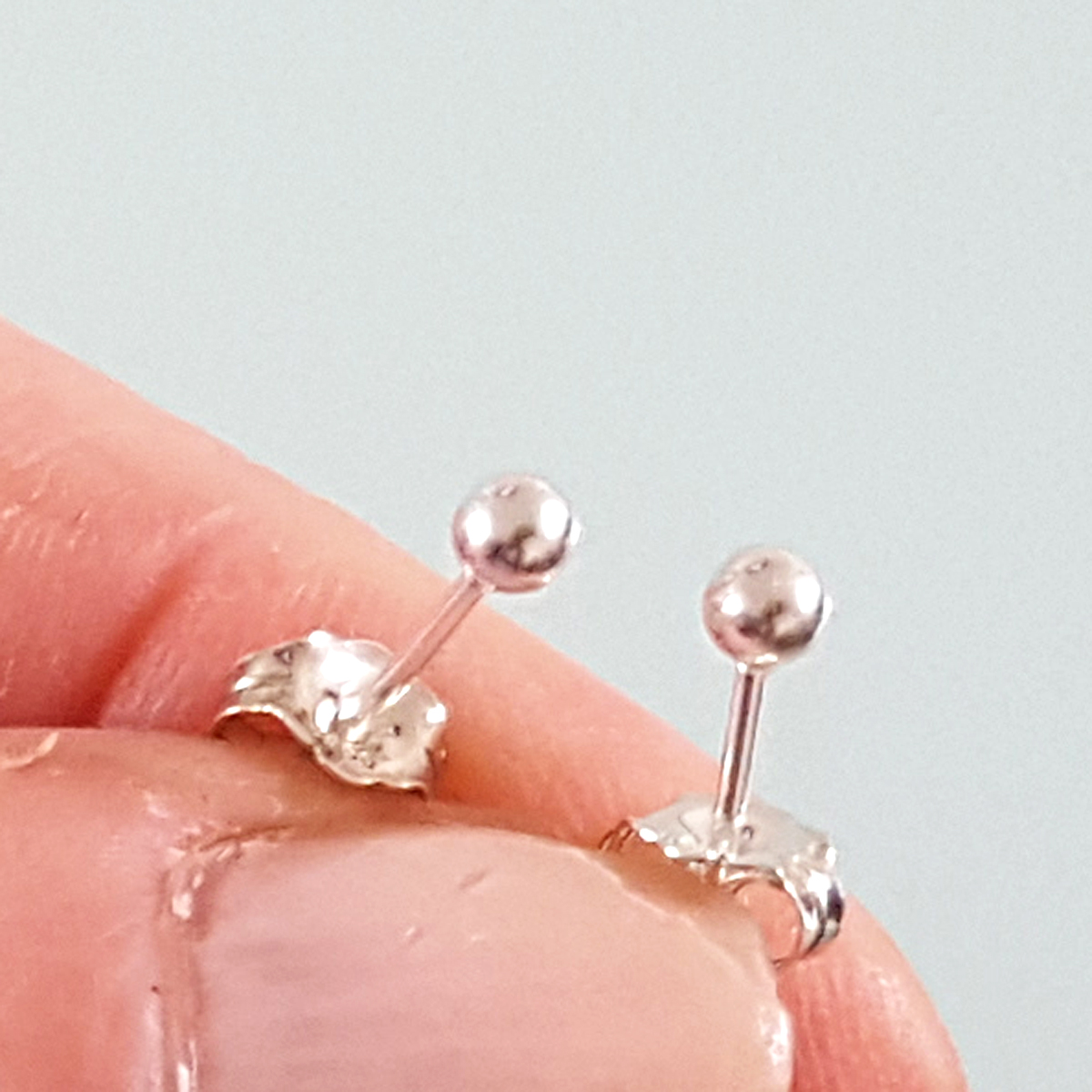 A pair of elegant 3 mm ball stud earrings made from sterling silver, featuring a secure disc butterfly back for comfortable wear.