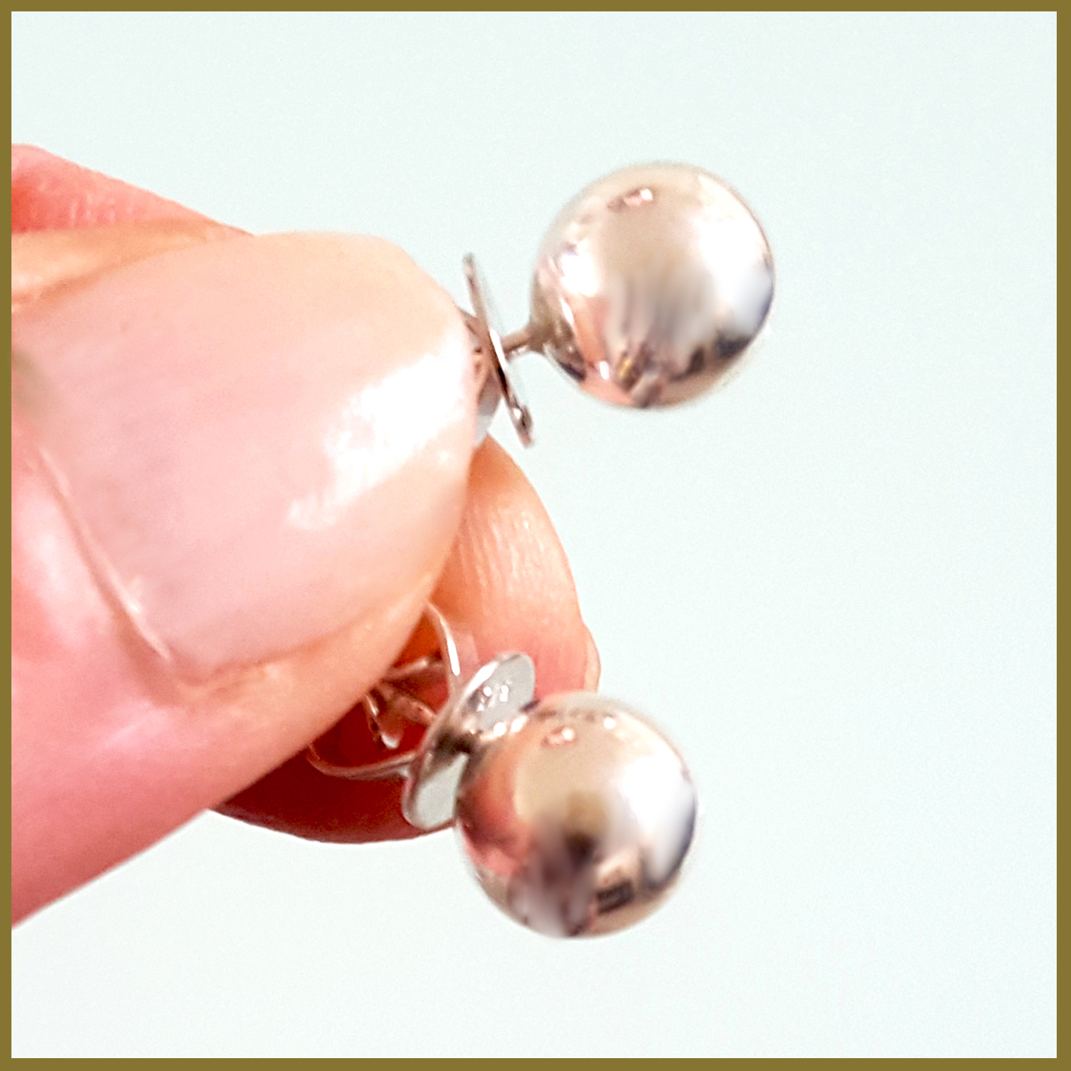 A pair of elegant sterling silver 8 mm ball stud earrings with a shiny finish, displayed on a soft fabric background.