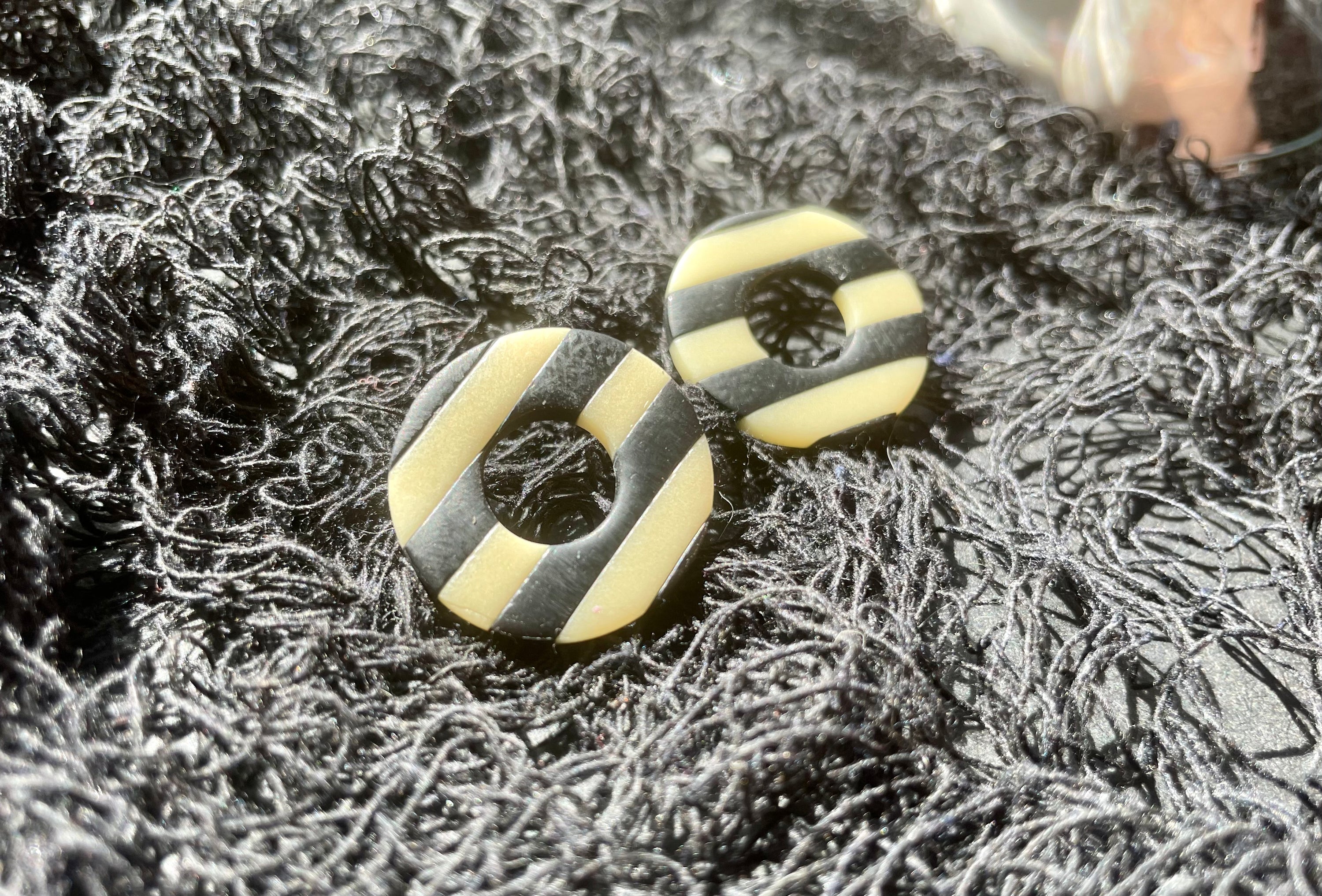 Handmade glow in the dark striped circle studs, showcasing unique patterns and colors, perfect for bold fashion statements.