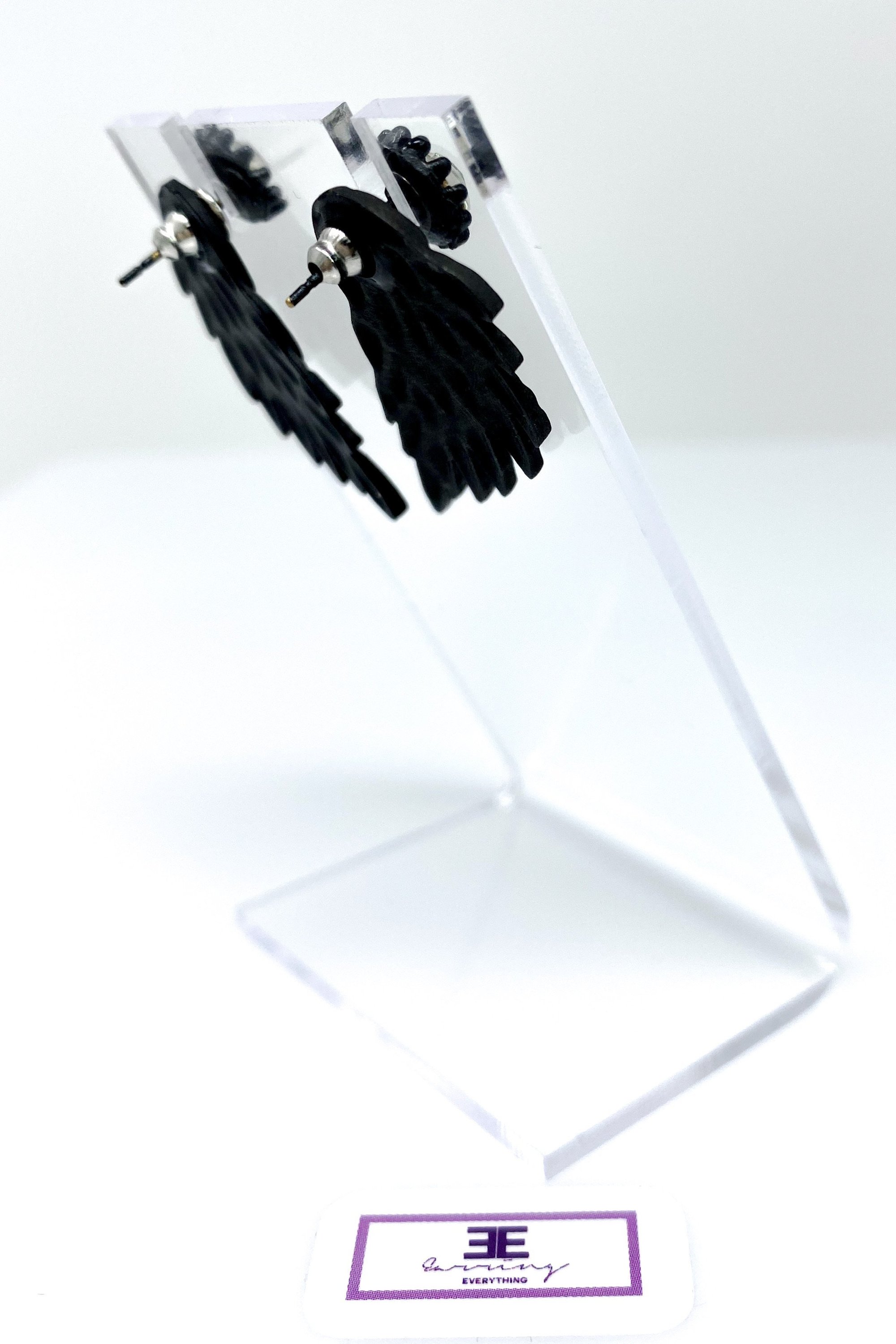 A pair of 420 Wingz Earrings featuring a unique wing design with a diamond accent, available in gold, silver, and black colors.