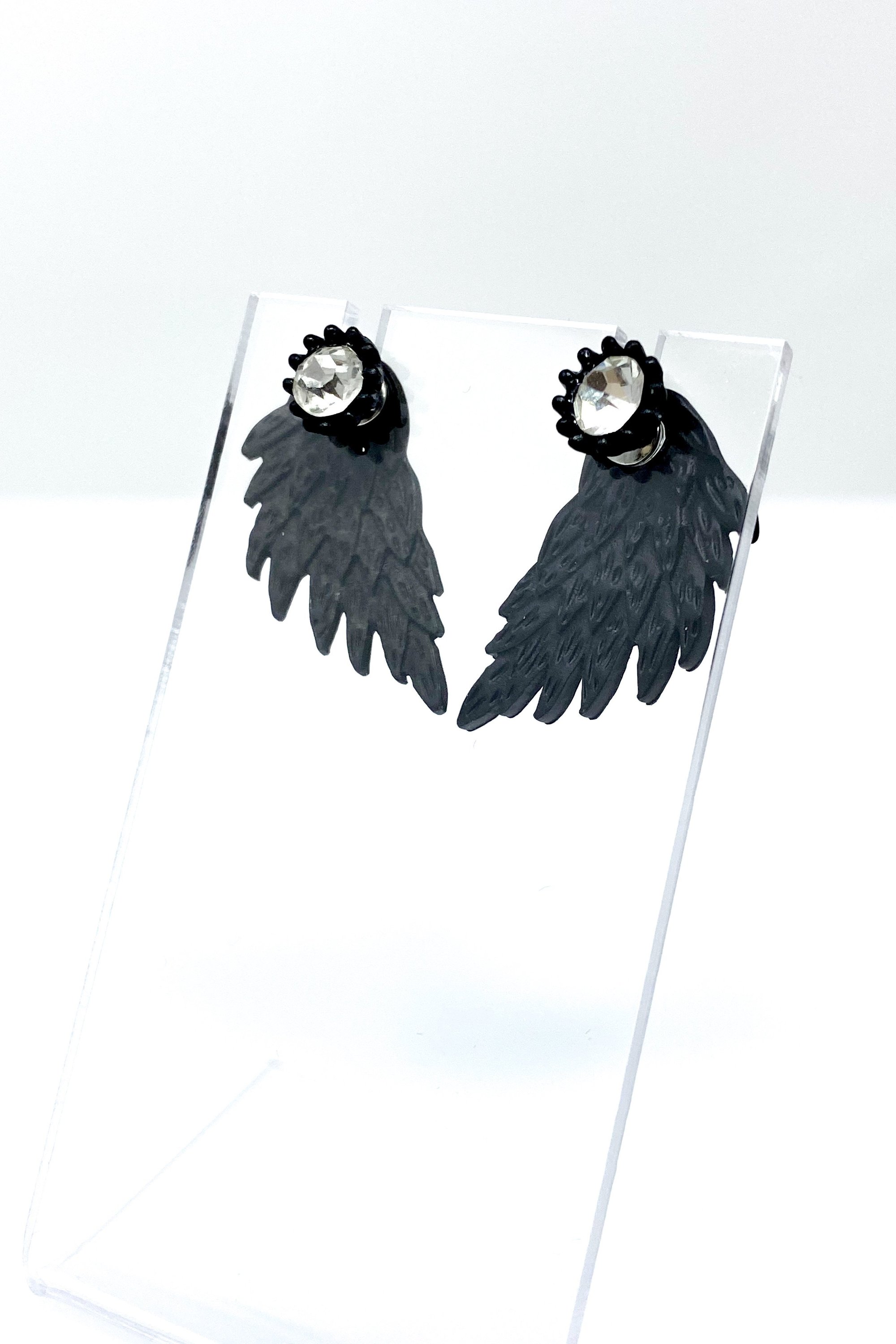 A pair of 420 Wingz Earrings featuring a unique wing design with a diamond accent, available in gold, silver, and black colors.