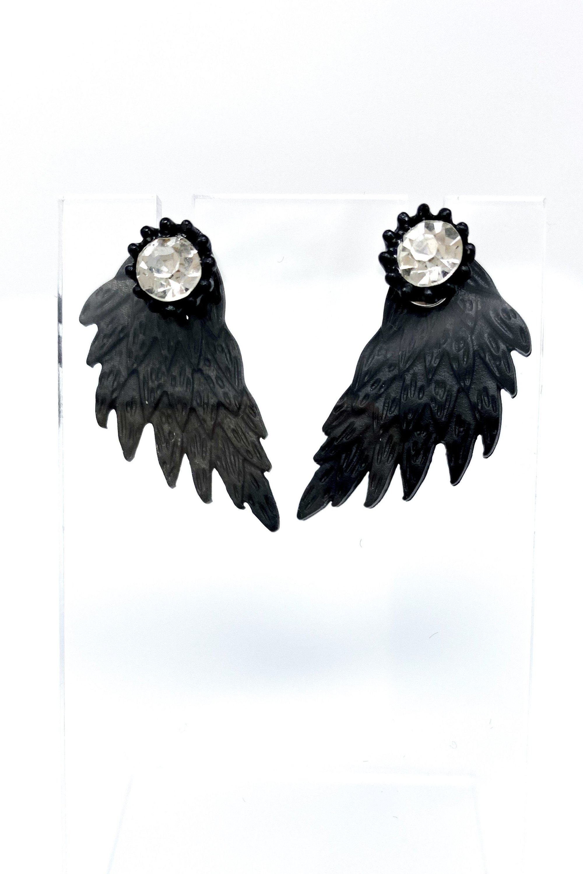 A pair of 420 Wingz Earrings featuring a unique wing design with a diamond accent, available in gold, silver, and black colors.