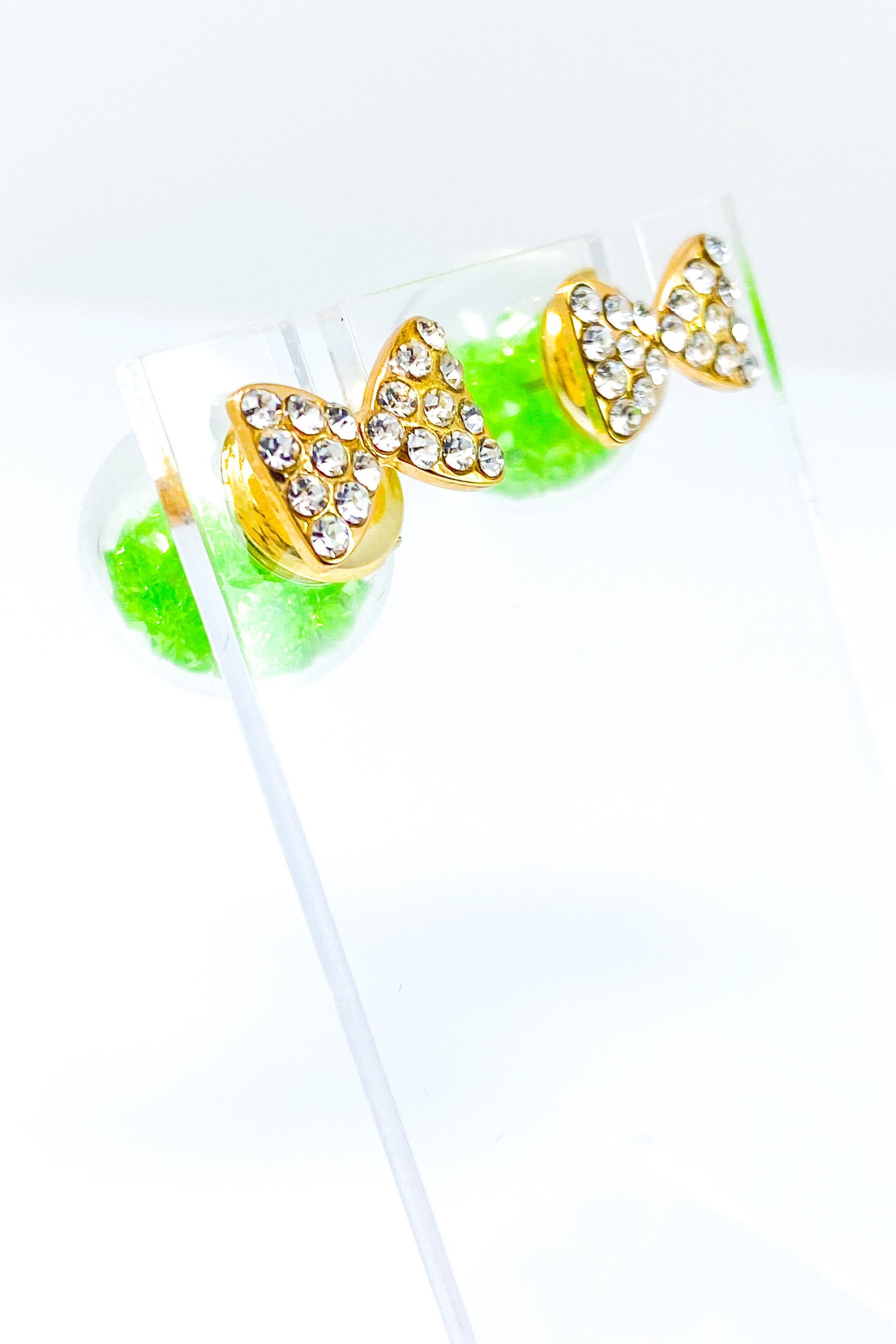 Bowtie Ice Studs featuring a sparkle bow tie design and moving ice ball, available in gold, blue, and green colors.