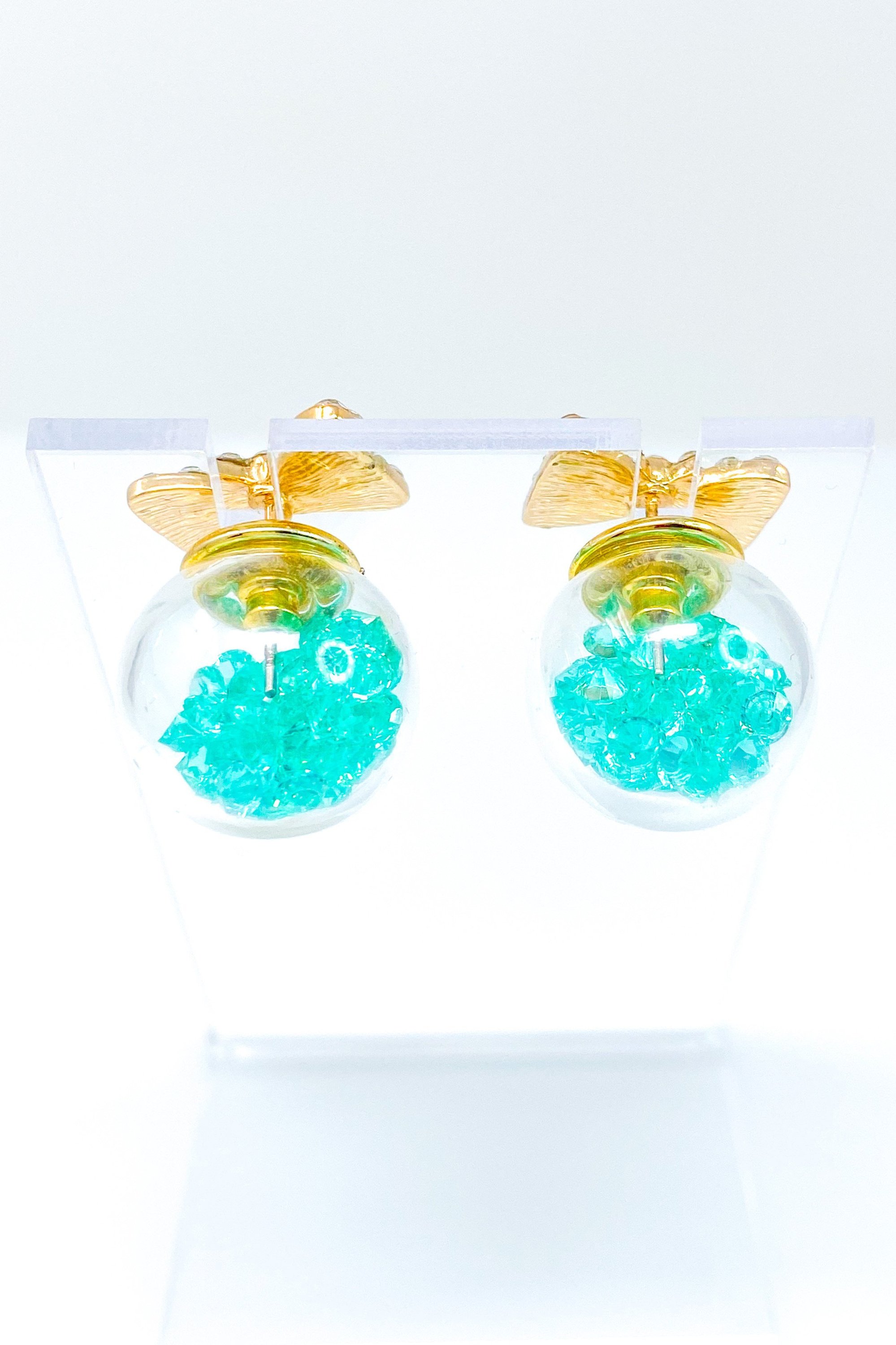 Bowtie Ice Studs featuring a sparkle bow tie design and moving ice ball, available in gold, blue, and green colors.