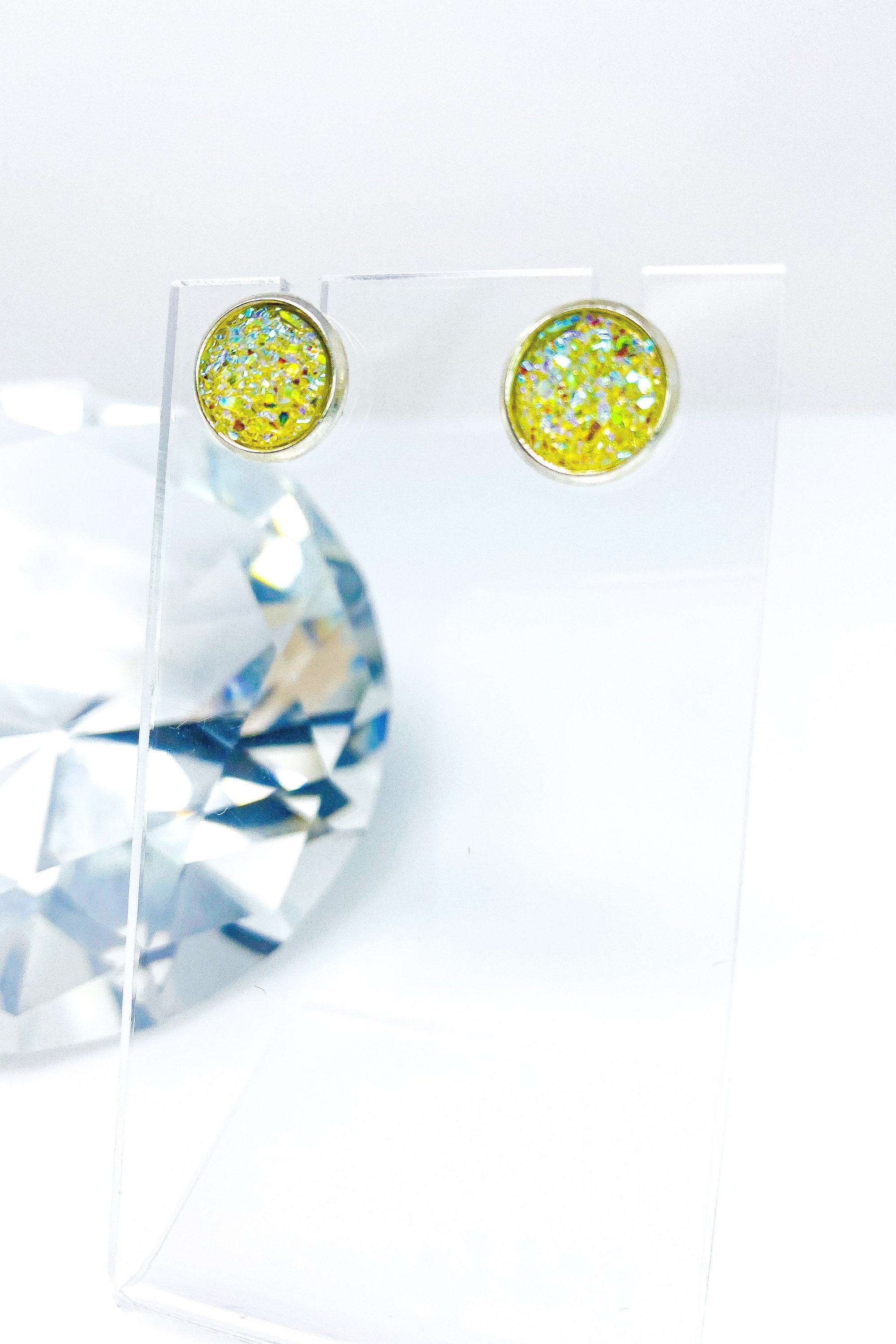 A pair of iridescent circular push back studs in vibrant colors, showcasing their geometric design and high-quality finish.