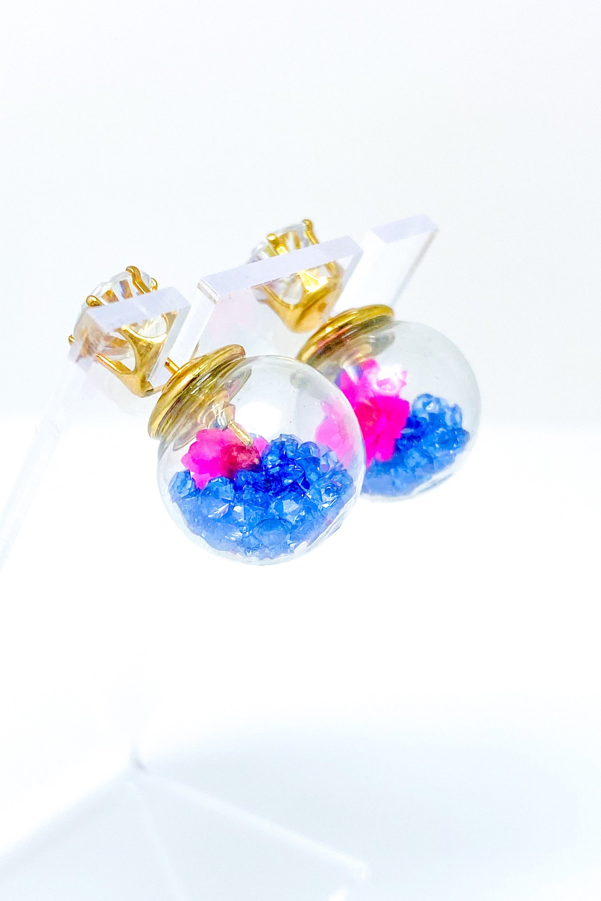 Perennial Ice Studs featuring handcrafted moving flowers and a plastique ice ball design in gold and multicolored options.