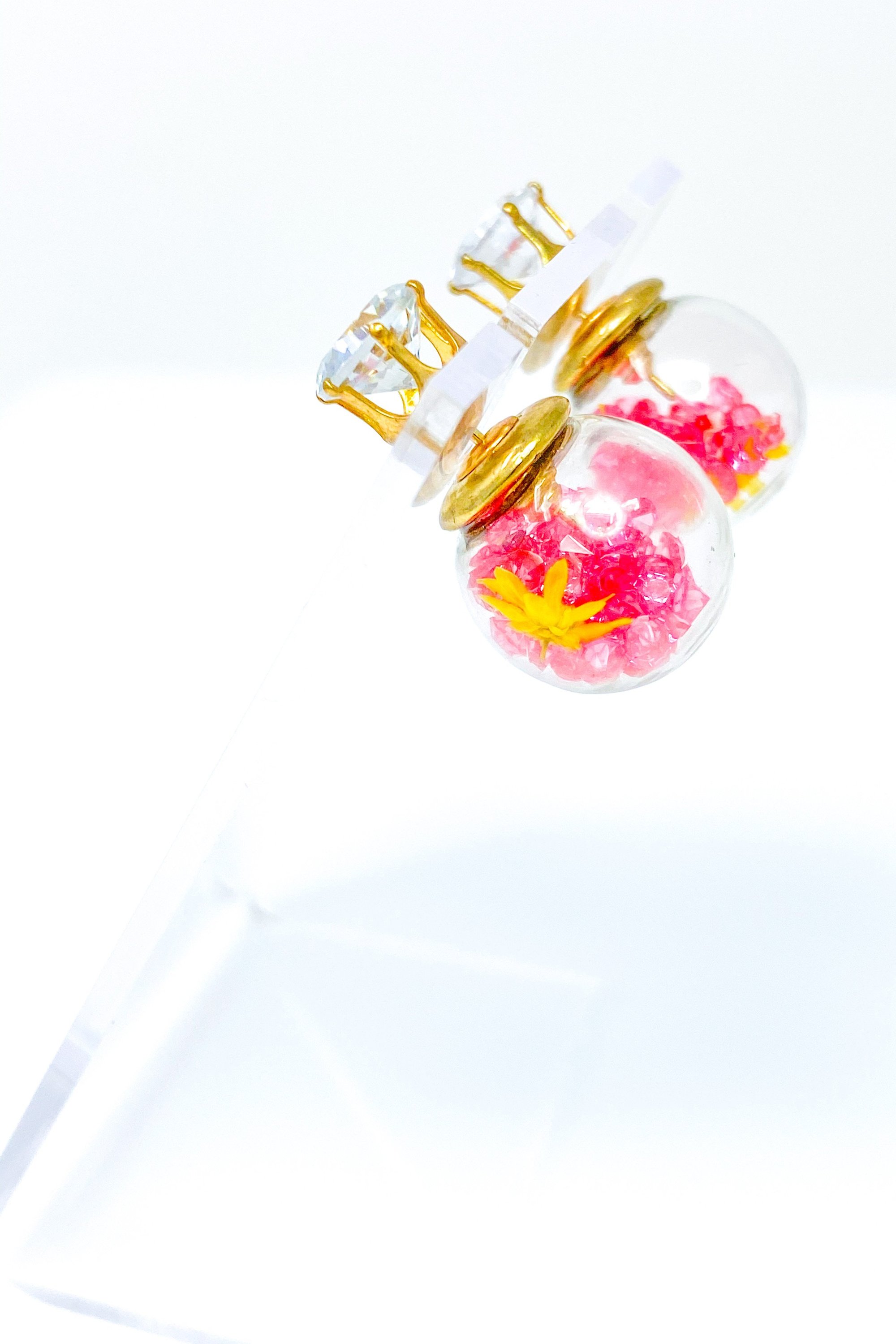 Perennial Ice Studs featuring handcrafted moving flowers and a plastique ice ball design in gold and multicolored options.