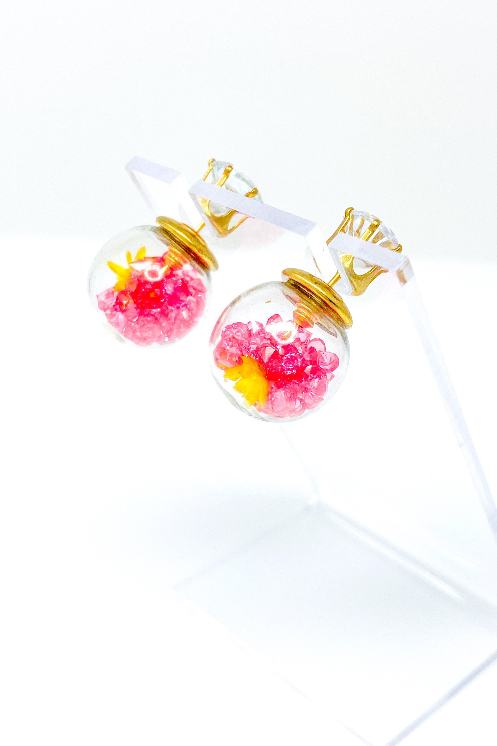 Perennial Ice Studs featuring handcrafted moving flowers and a plastique ice ball design in gold and multicolored options.