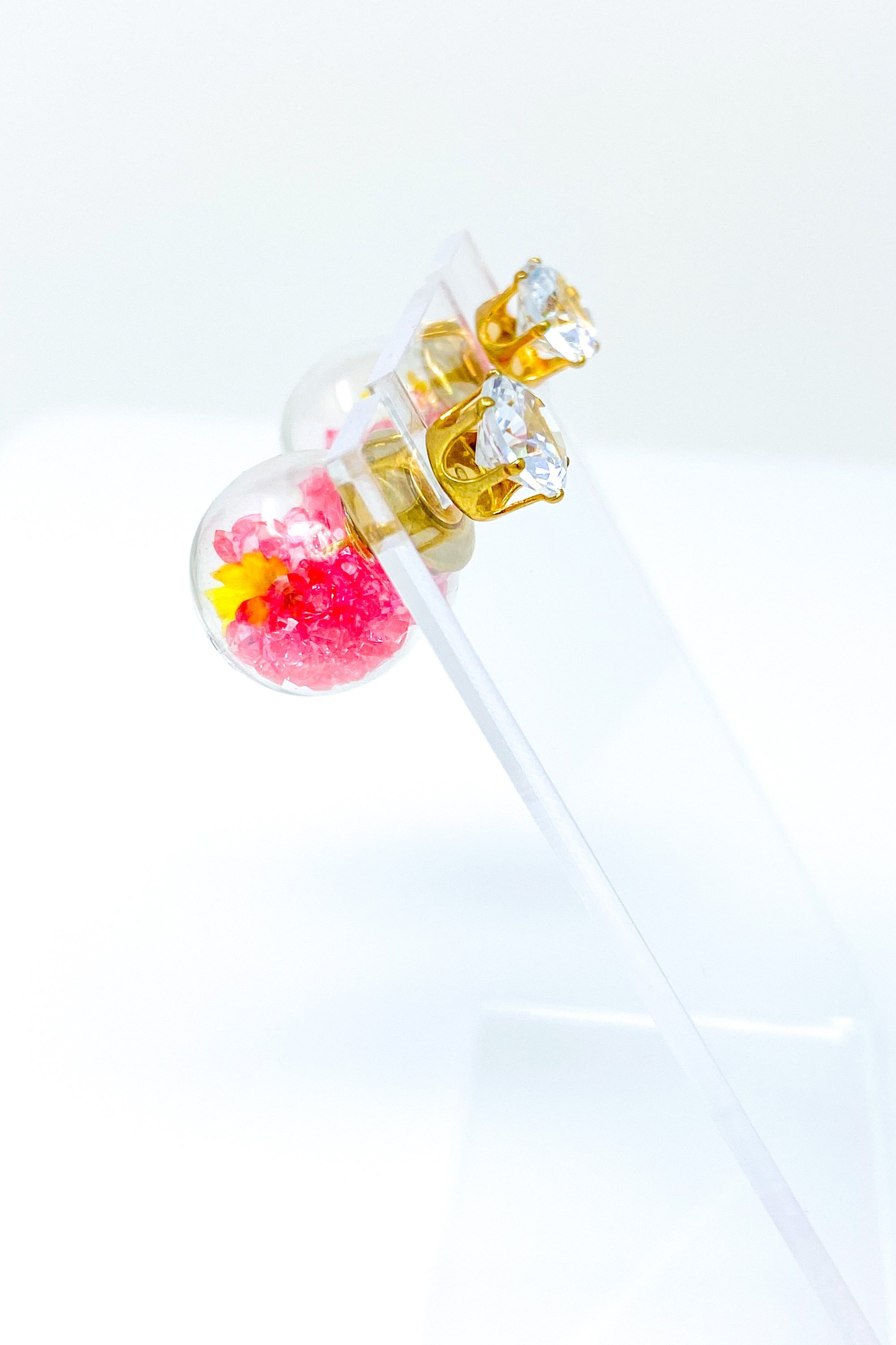 Perennial Ice Studs featuring handcrafted moving flowers and a plastique ice ball design in gold and multicolored options.