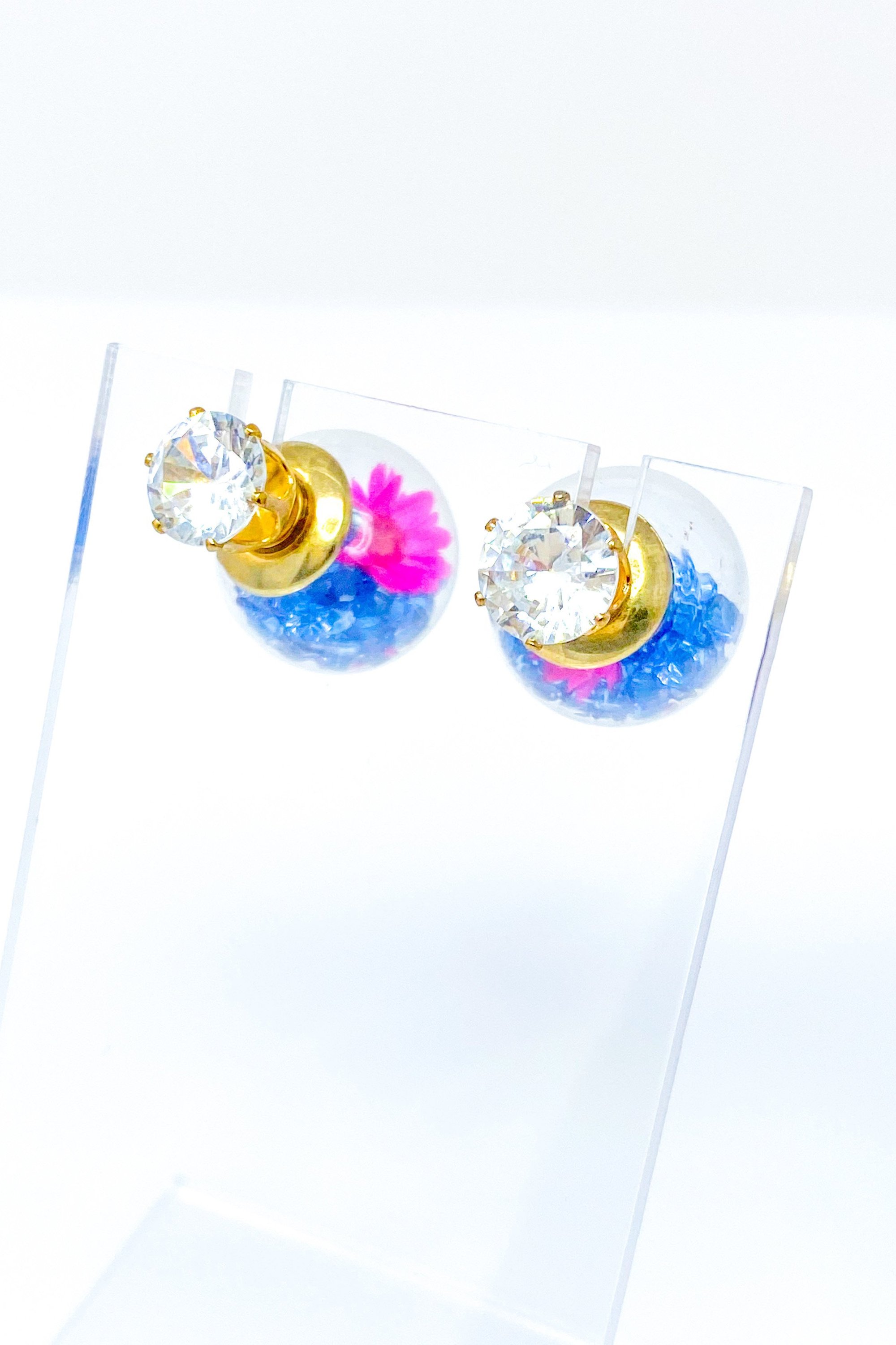 Perennial Ice Studs featuring handcrafted moving flowers and a plastique ice ball design in gold and multicolored options.